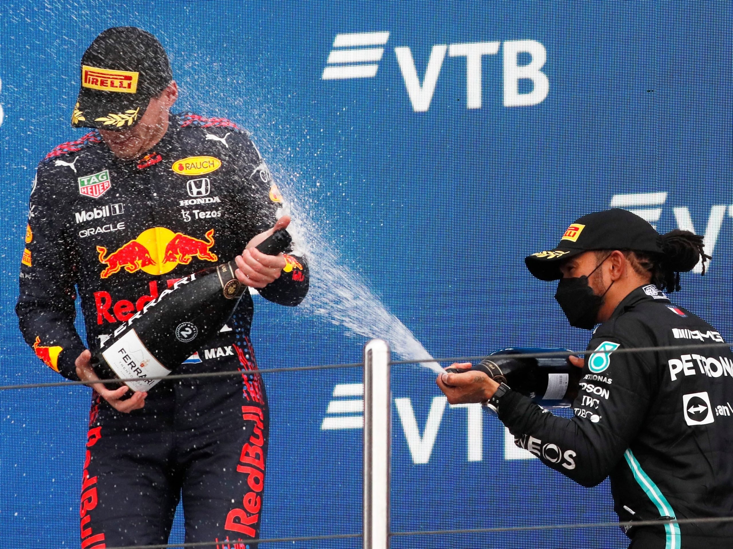 Max Verstappen is sprayed by champagne by Lewis Hamilton