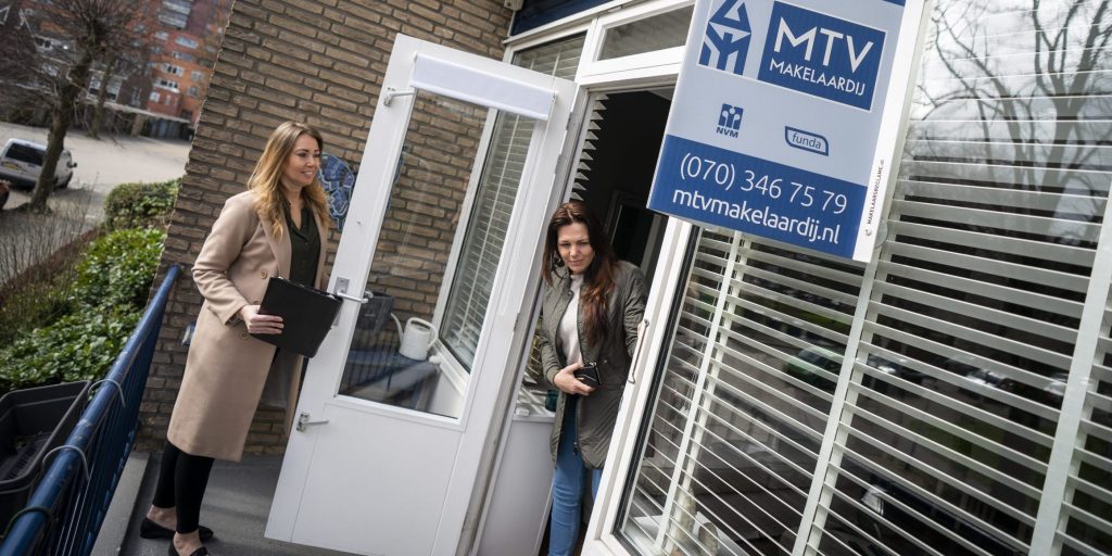 Een belangstellende wordt door een makelaar rondgeleid tijdens een bezichtiging aan een woning in Den Haag.