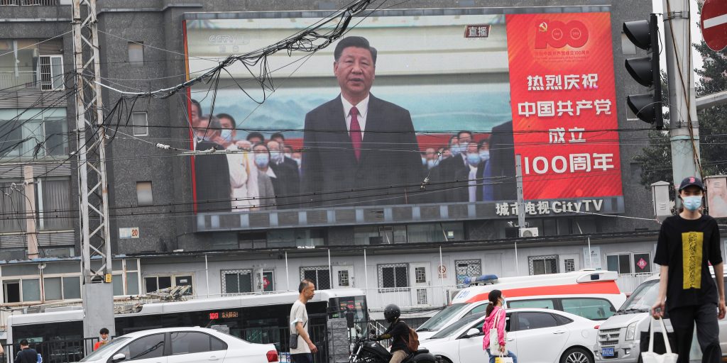 De Chinese president Xi Jinping tijdens het zingen van het volkslied in Beijing op een reusachtig scherm.