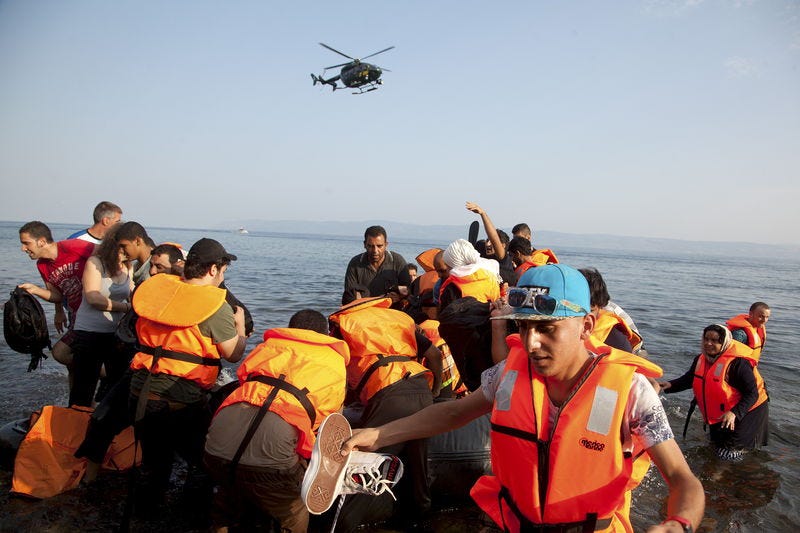 Frontex helicopter patrols over Syrian refugees arriving on an overcrowded dinghy at a beach at the Greek island of Lesbos August 10, 2015. REUTERS/Antonis Pasvantis