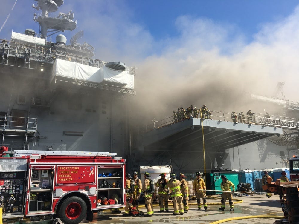 Firefighters battle a fire aboard the US Navy amphibious assault ship USS Bonhomme Richard