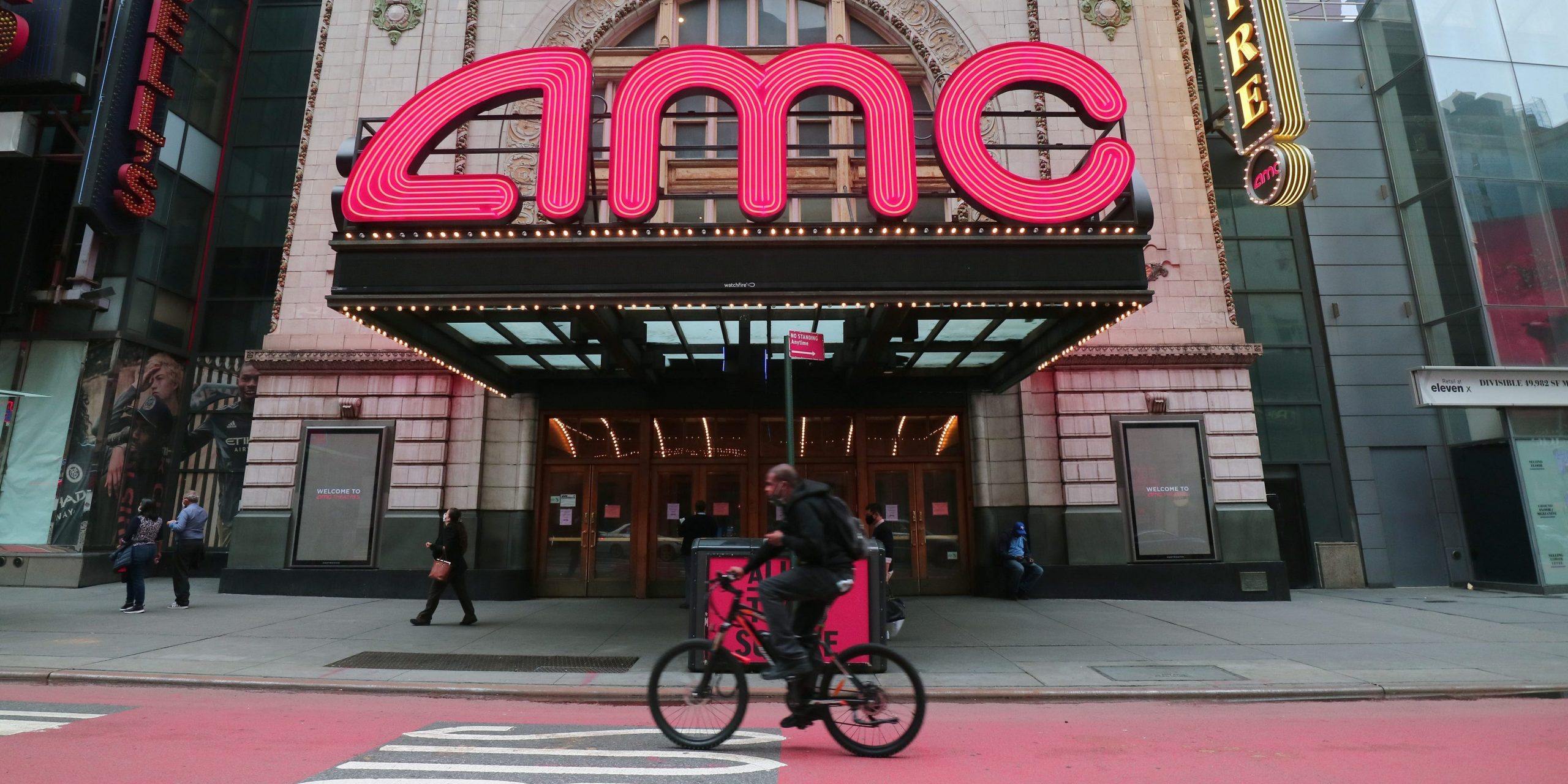 A person rides his bicycle past the closed AMC movie theaters in Times Square on October 22, 2020.