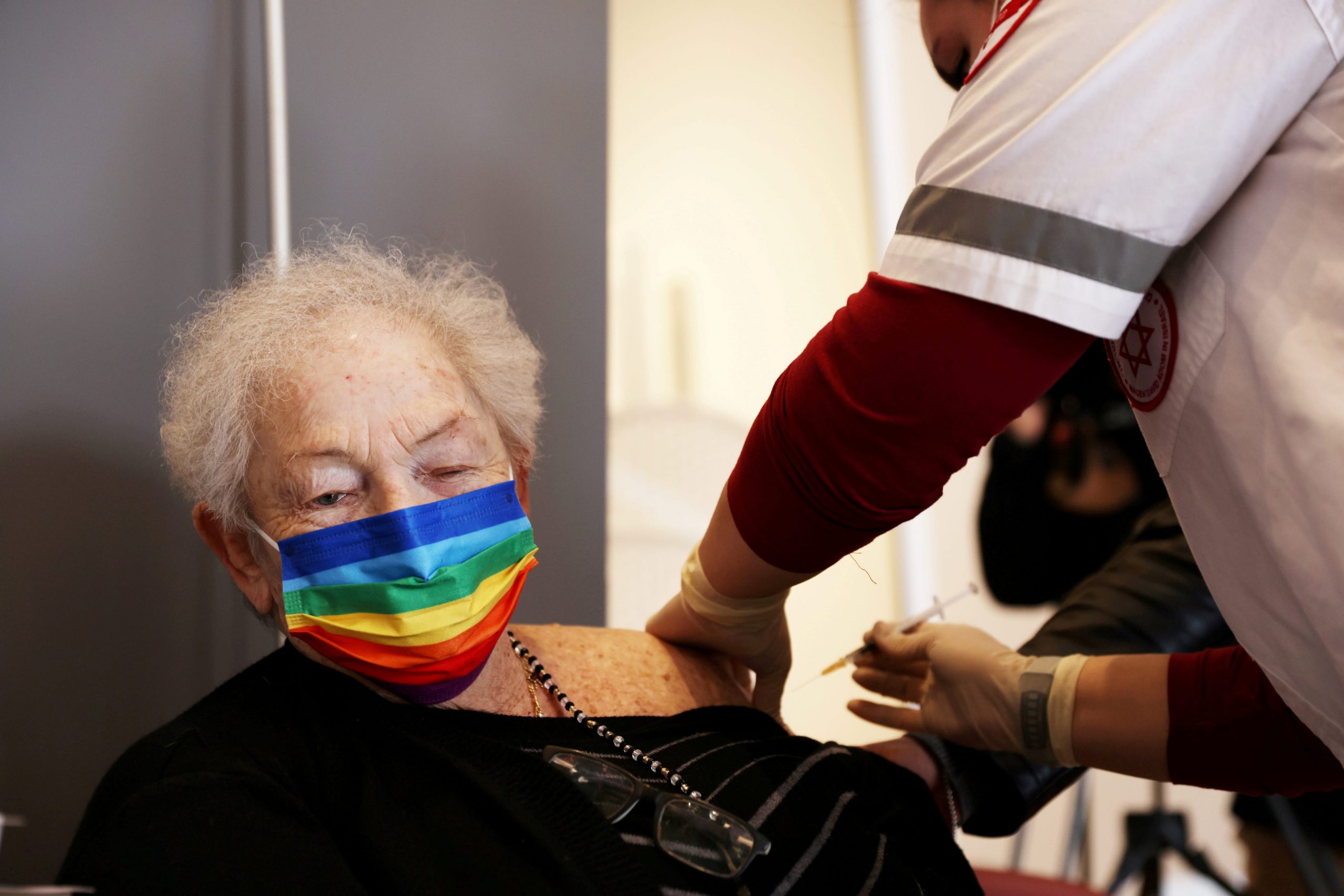 An elderly woman receives a booster shot of her vaccination against the coronavirus disease (COVID-19) at an assisted living facility, in Netanya, Israel, January 19, 2021.