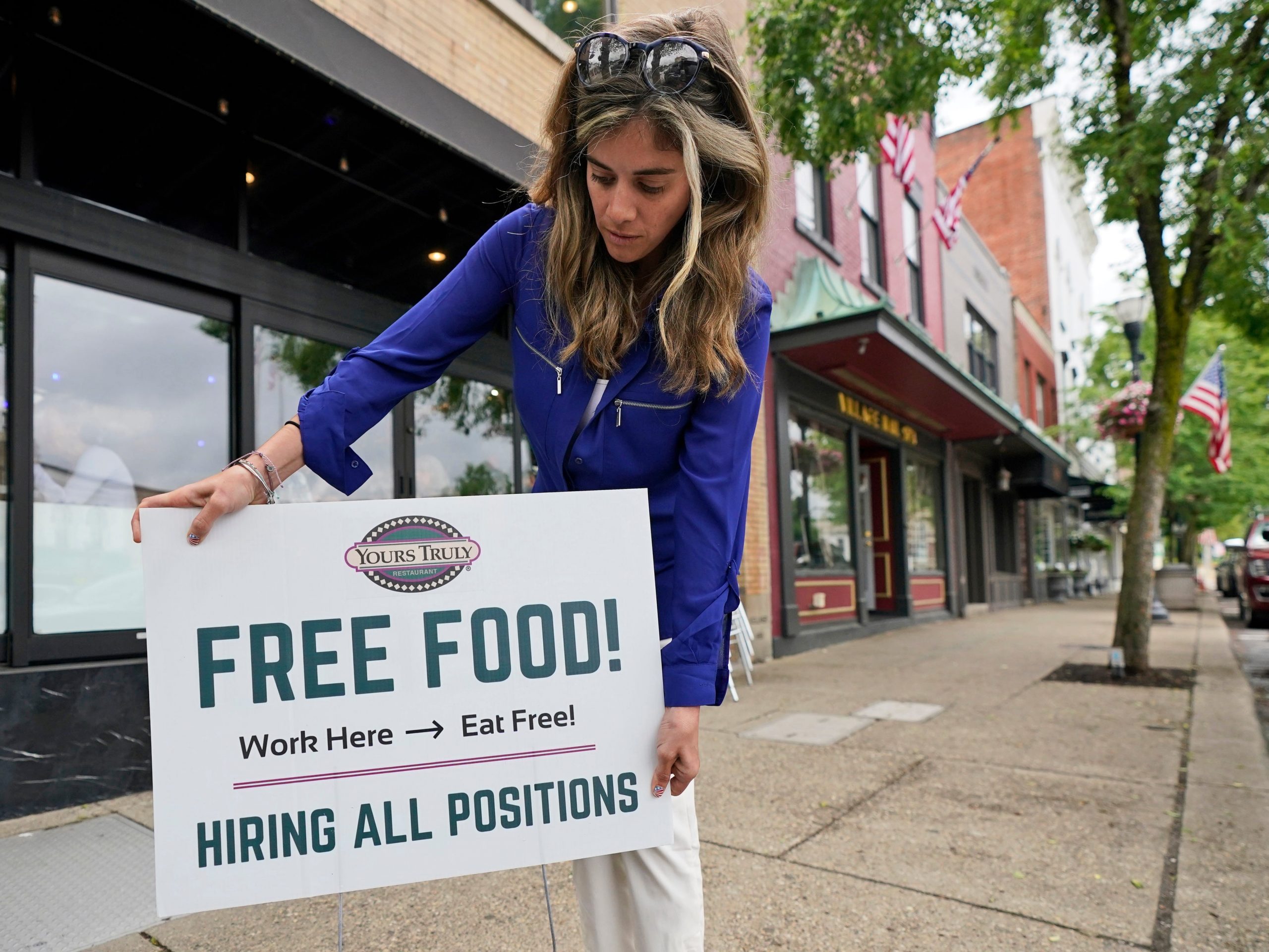 Coleen Piteo, director of marketing at Yours Truly restaurant, puts out a sign that says, "Free Food" and "Hiring all positions" to lure in job applicants.