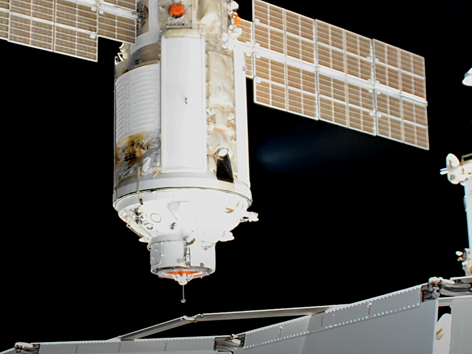 nauka module spaceship with solar array wings approaches international space station