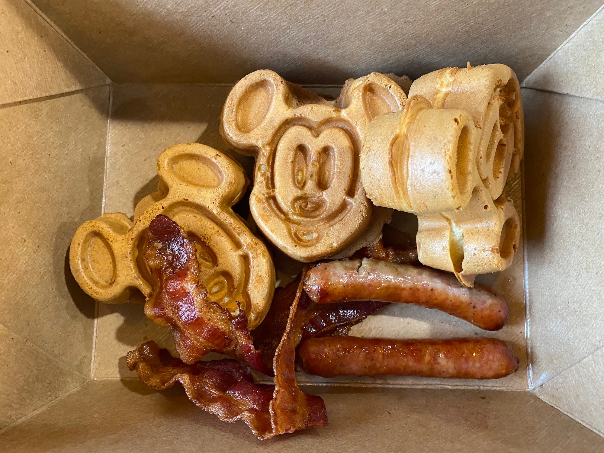 Mickey Mouse waffles with sides of bacon and sausage in 2021.