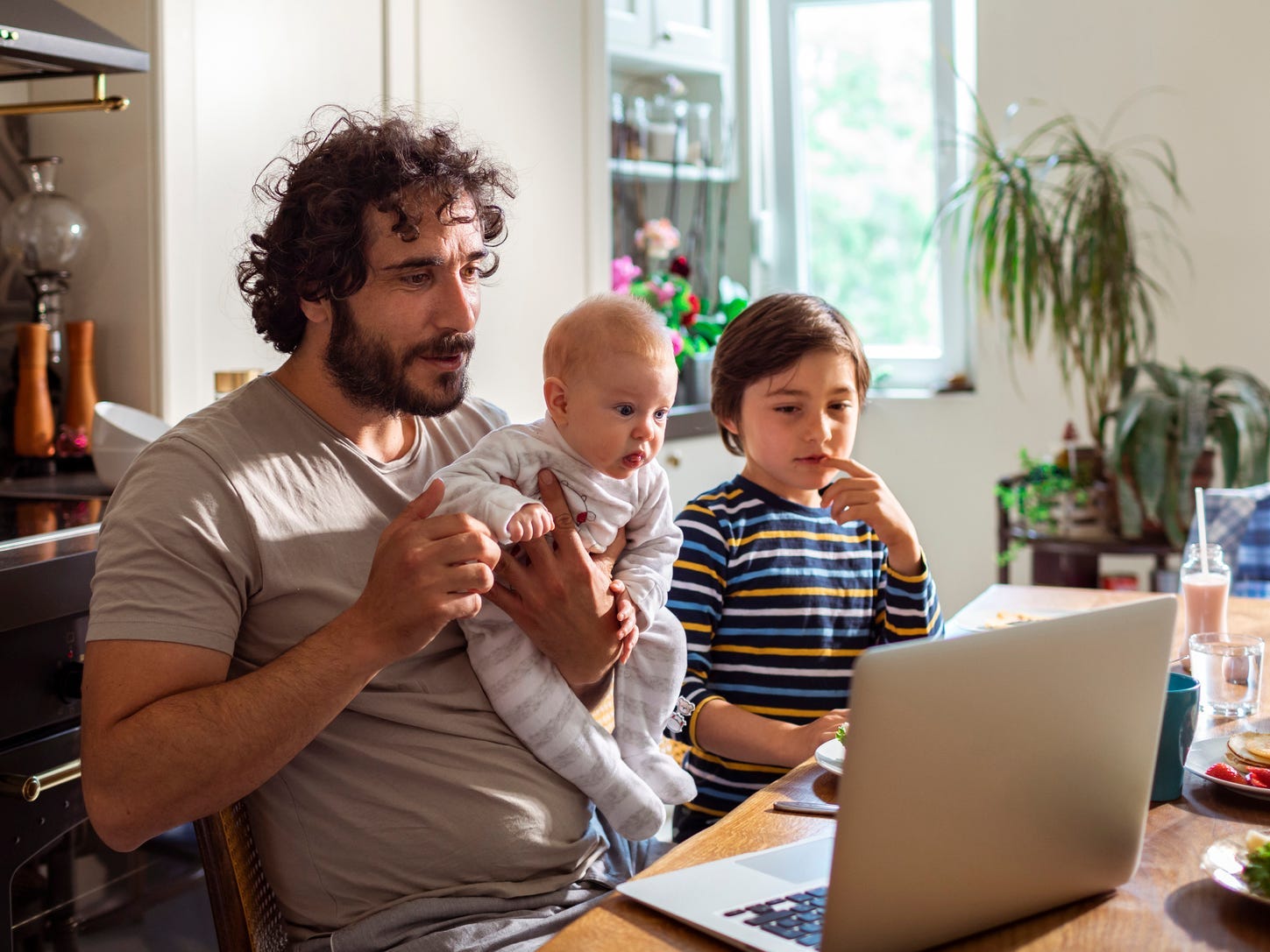 dad working from home with two children in kitchen