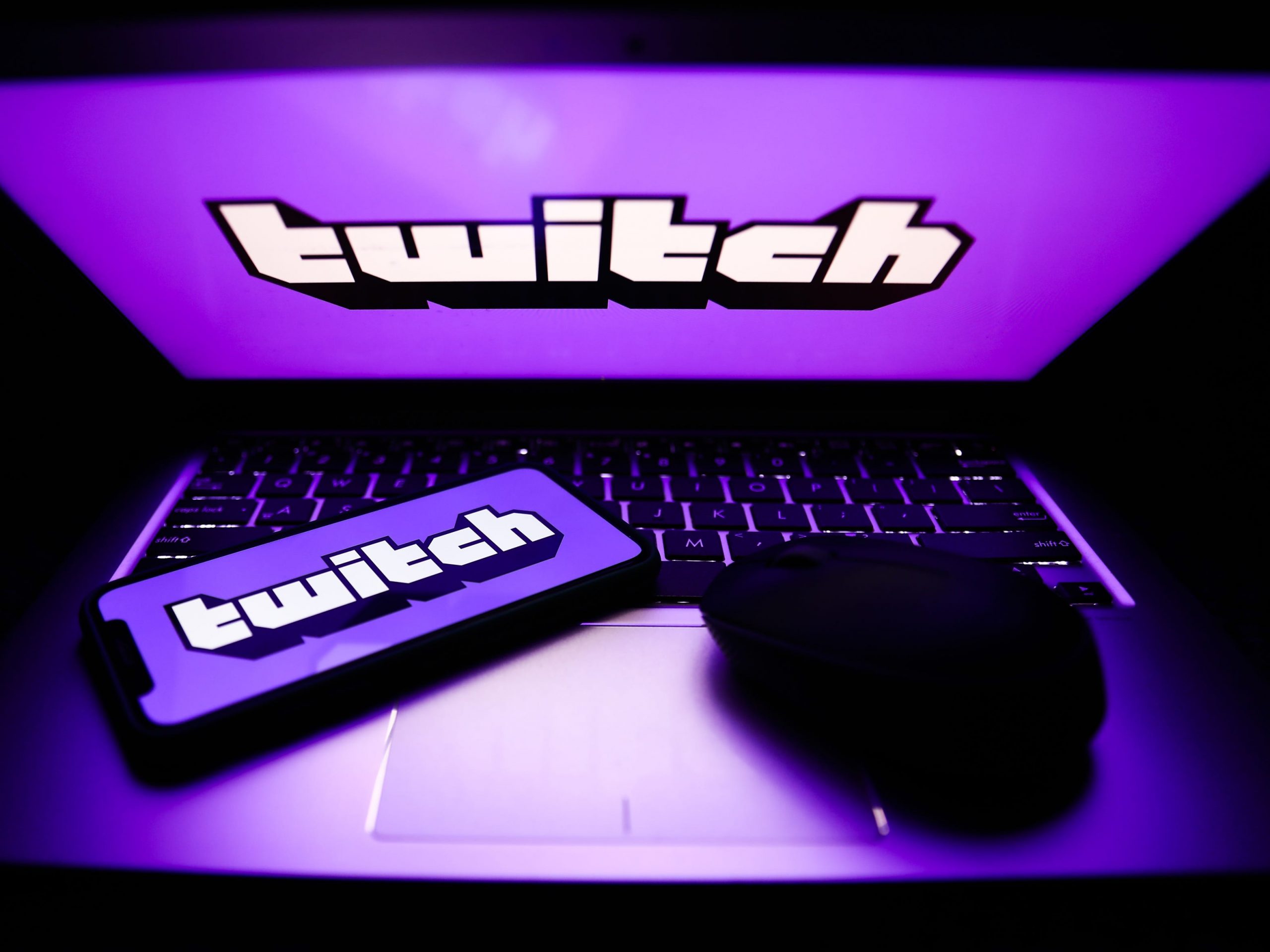 Twitch logos are seen displayed on a phone and a laptop screens in this illustration photo.
