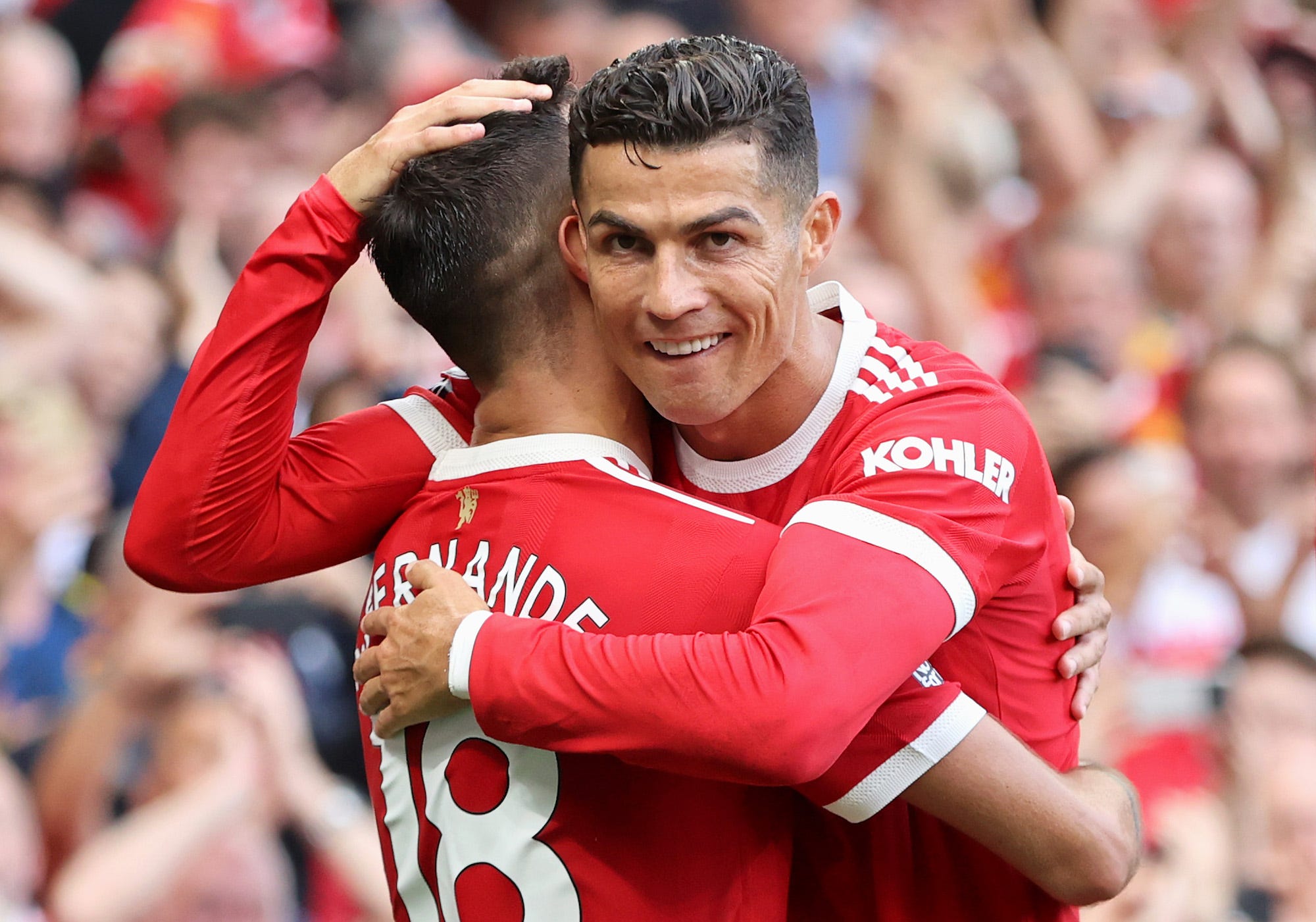 Bruno Fernandes of Manchester United celebrates with Cristiano Ronaldo after scoring their side's third goal during the Premier League match between Manchester United and Newcastle United at Old Trafford
