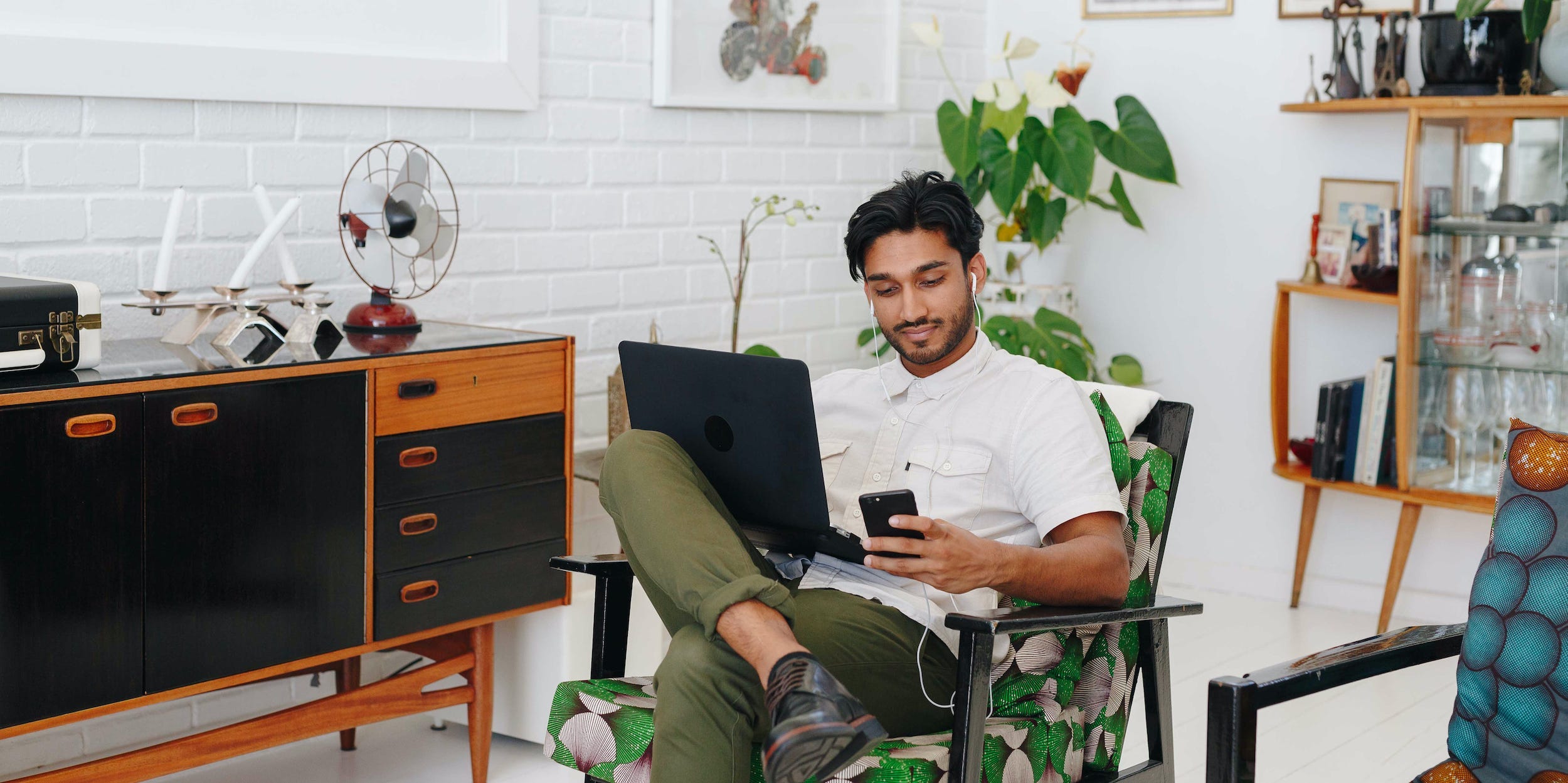 man using laptop and phone at home