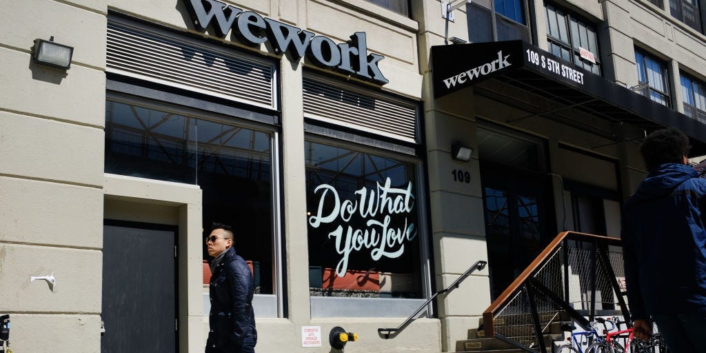 People walk by the co-working space WeWork in the Williamsburg neighborhood in Brooklyn on March 26, 2019 in New York