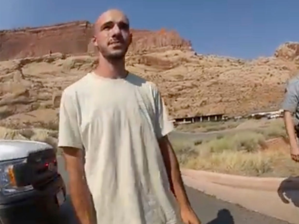 Brian Laundrie in the desert with a cop behind him