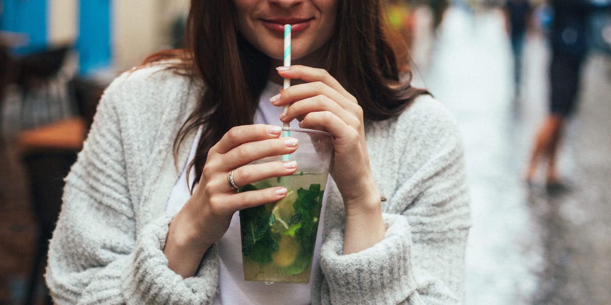 A woman drinking a mojito.