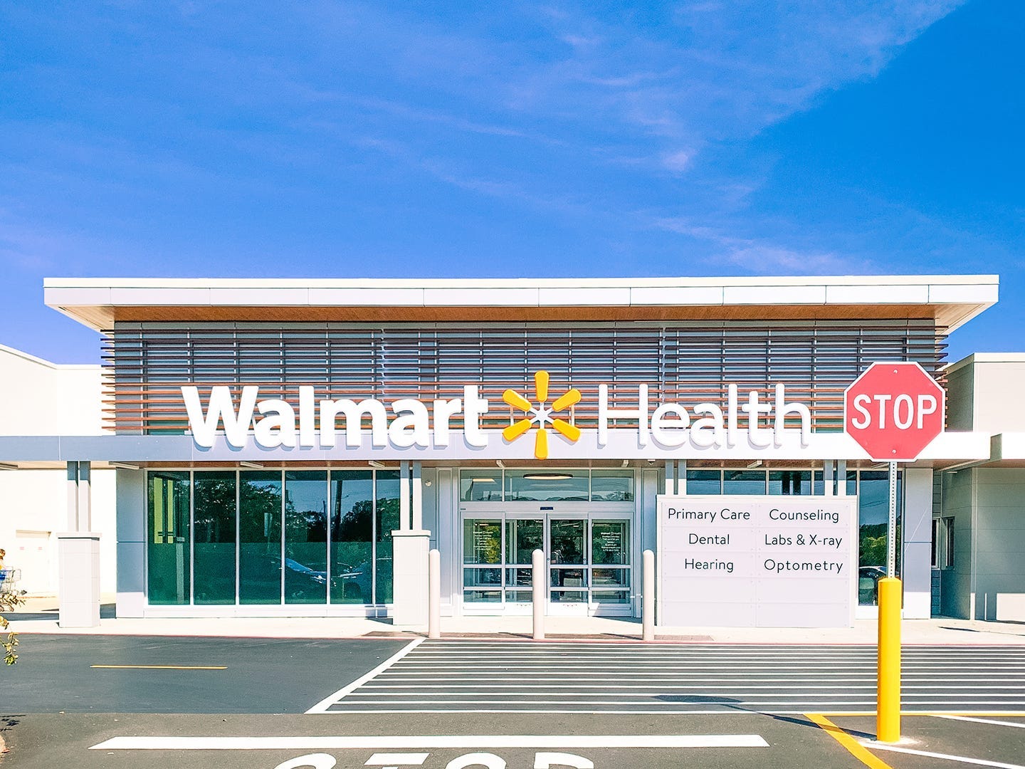 A building with a sign out front that says Walmart Health and a parking lot