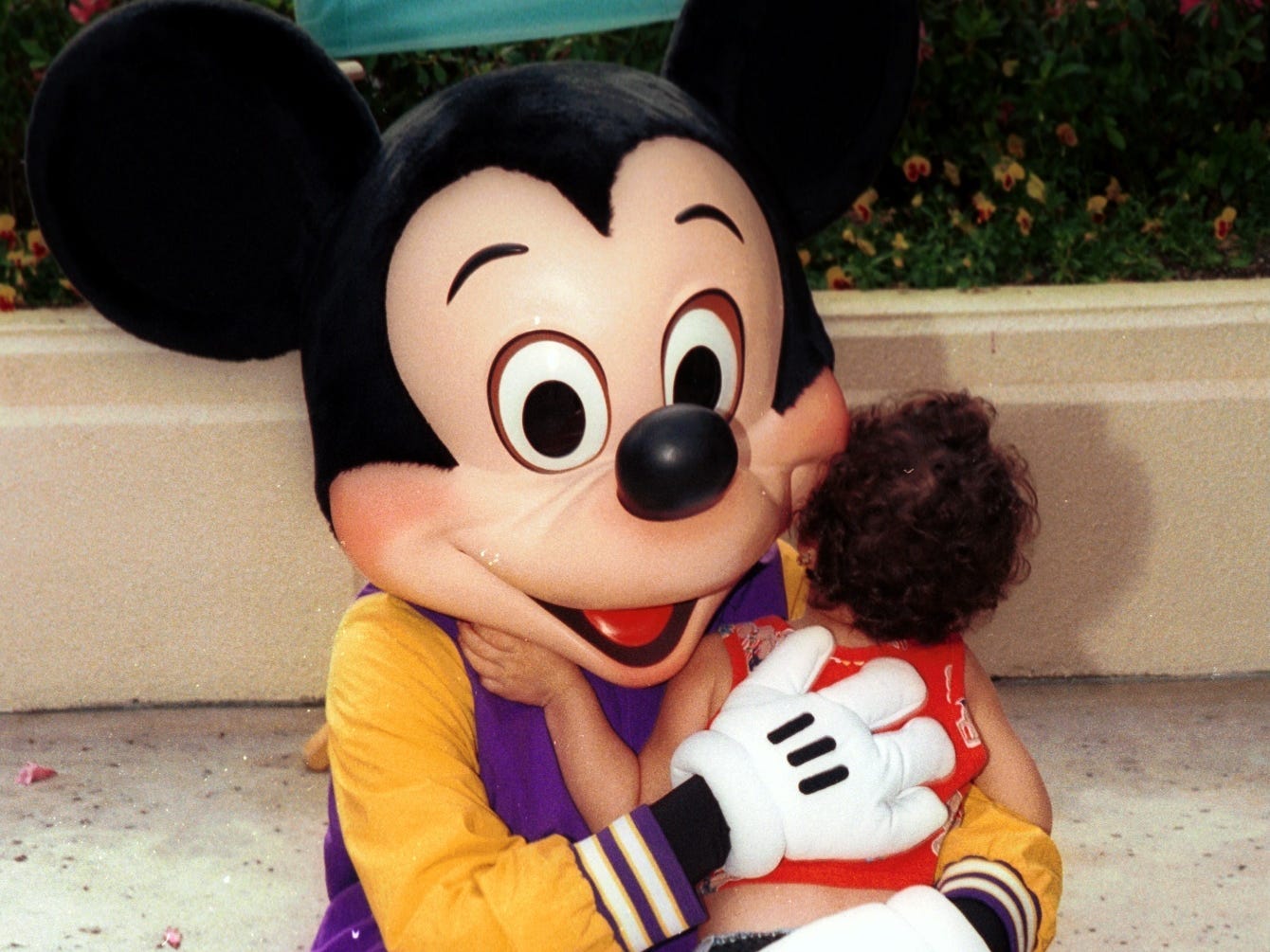 mickey mouse hugging a kid