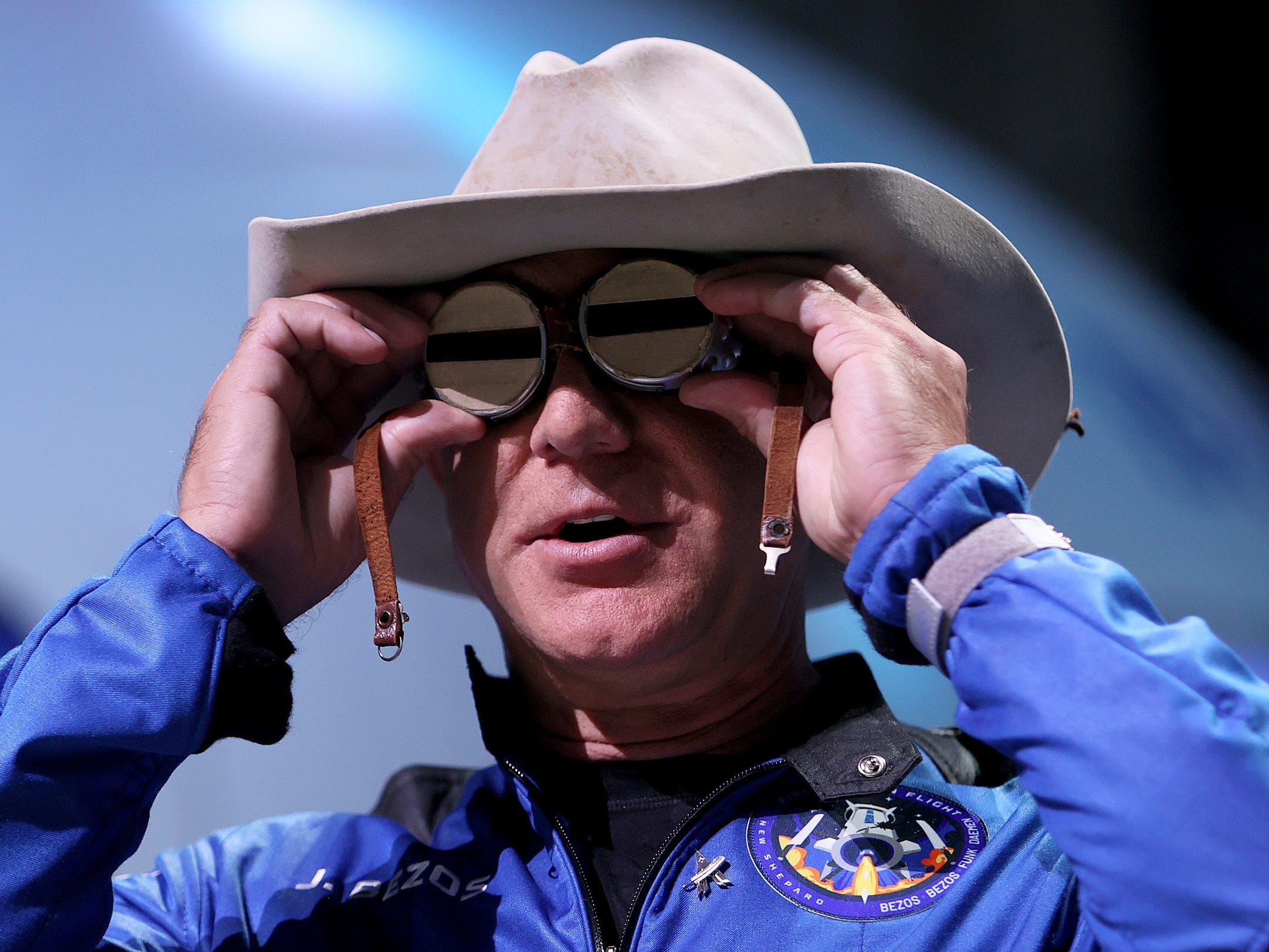 Blue Origin founder Jeff Bezos wears a pair of reflective aviation glasses under a cowboy hat