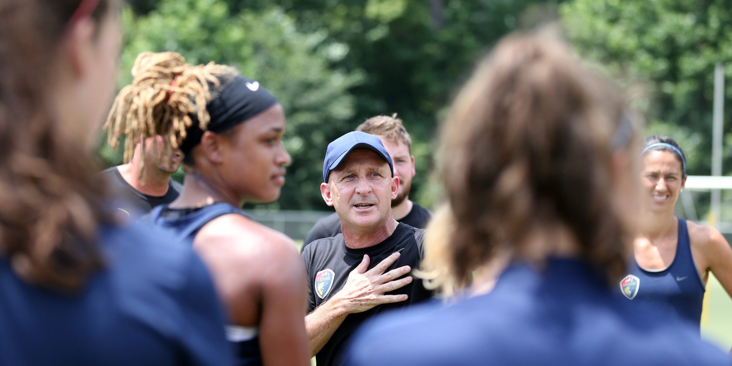 Paul Riley surrounded by North Carolina Courage soccer players.