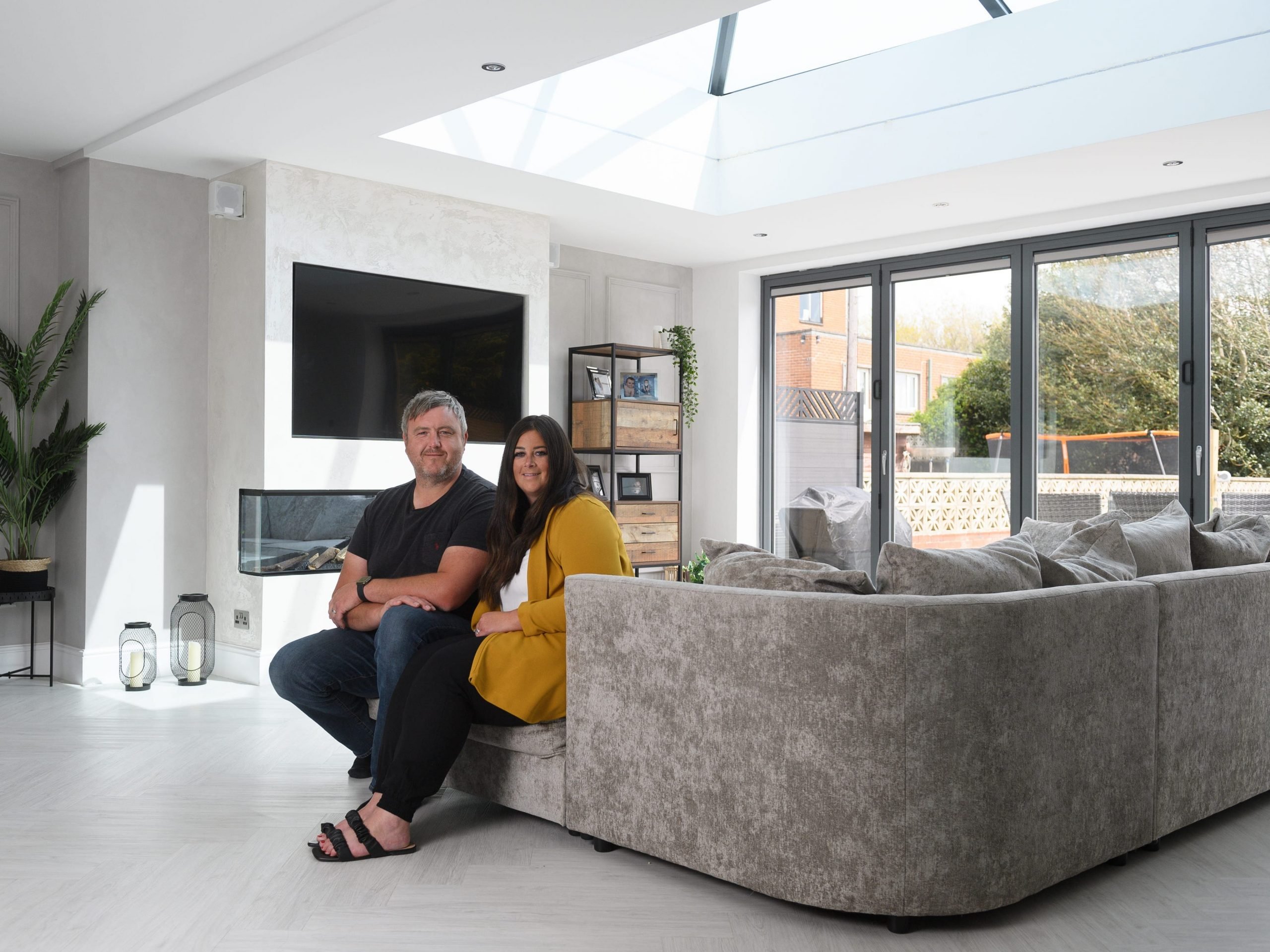 Natalie and Andrew Cunliffe sitting on the couch of their renovated 1930s home.