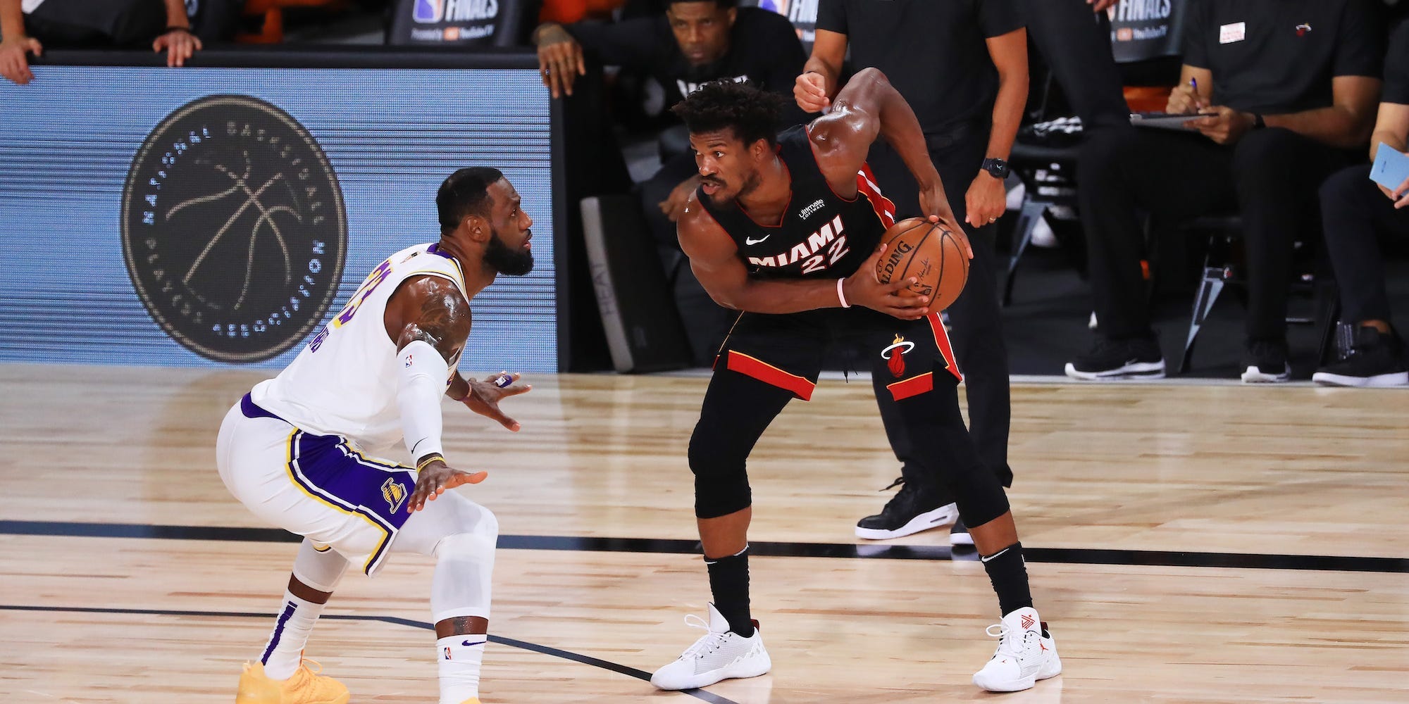 Jimmy Butler holds the ball while being defended by LeBron James in the 2020 Finals.