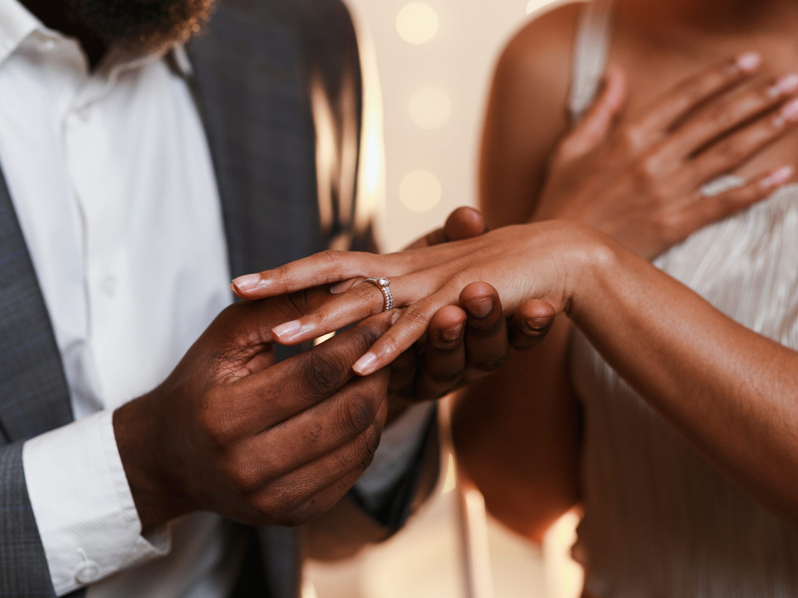 Guy putting engagement ring on girl's finger proposal