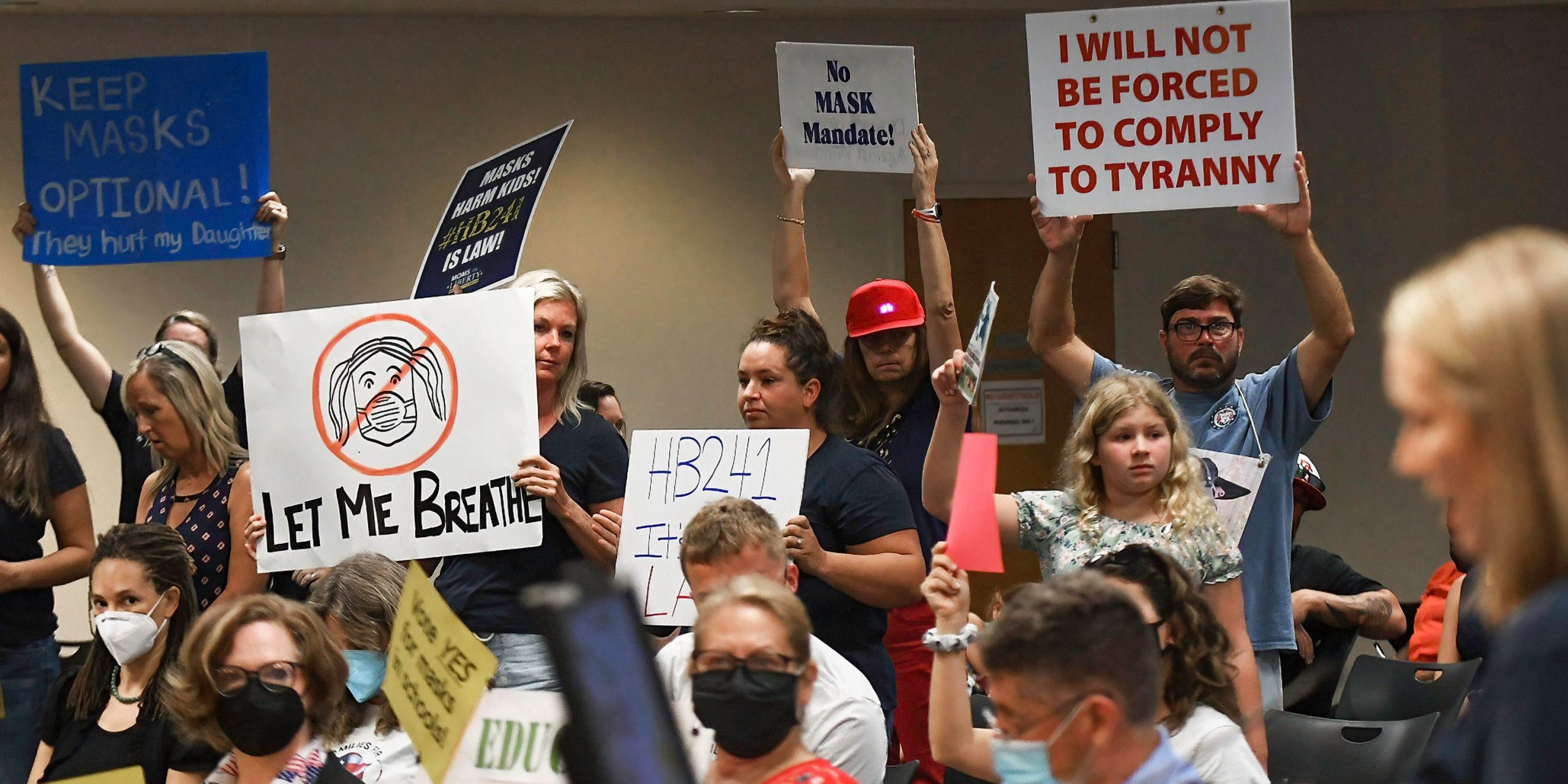 People demonstrate at an emergency meeting of the Brevard County, Florida School Board in Viera to discuss whether face masks in local schools should be mandatory.