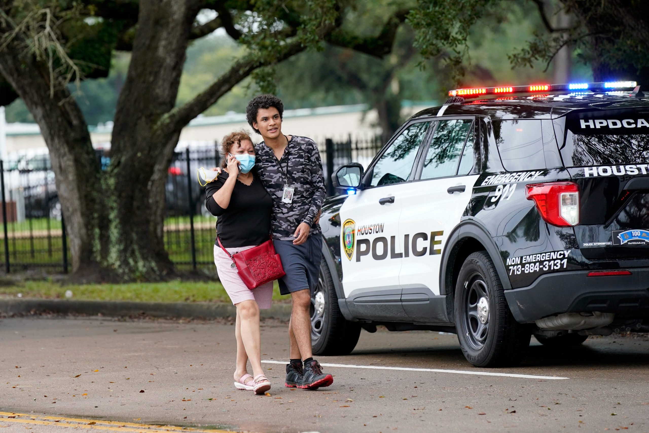 People walk down the road outside YES Prep Southwest Secondary school after a shooting on Friday, Oct. 1, 2021 in Houston.