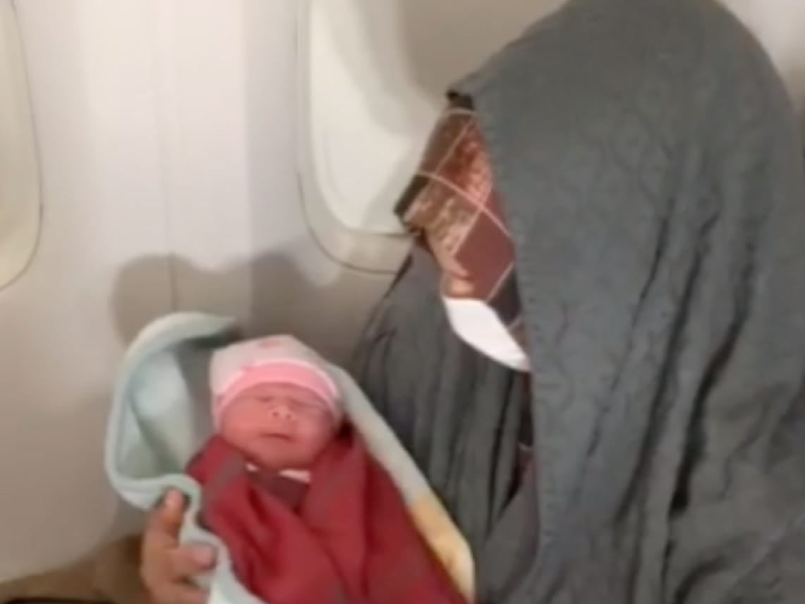 Mother holds newborn son that was born on Turkish Airlines' flight.