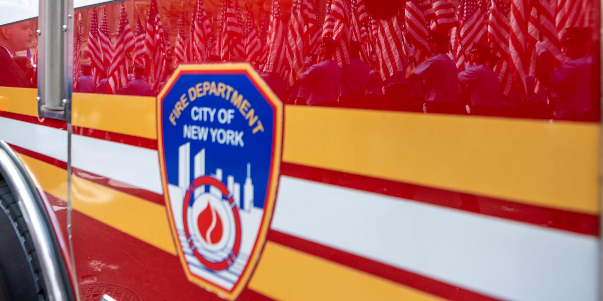 Members of the New York City Fire Department carrying American flags are reflected off a fire truck during a processional during the FDNY Memorial Service at St. Patrick's Cathedral on September 11, 2021 in New York City.