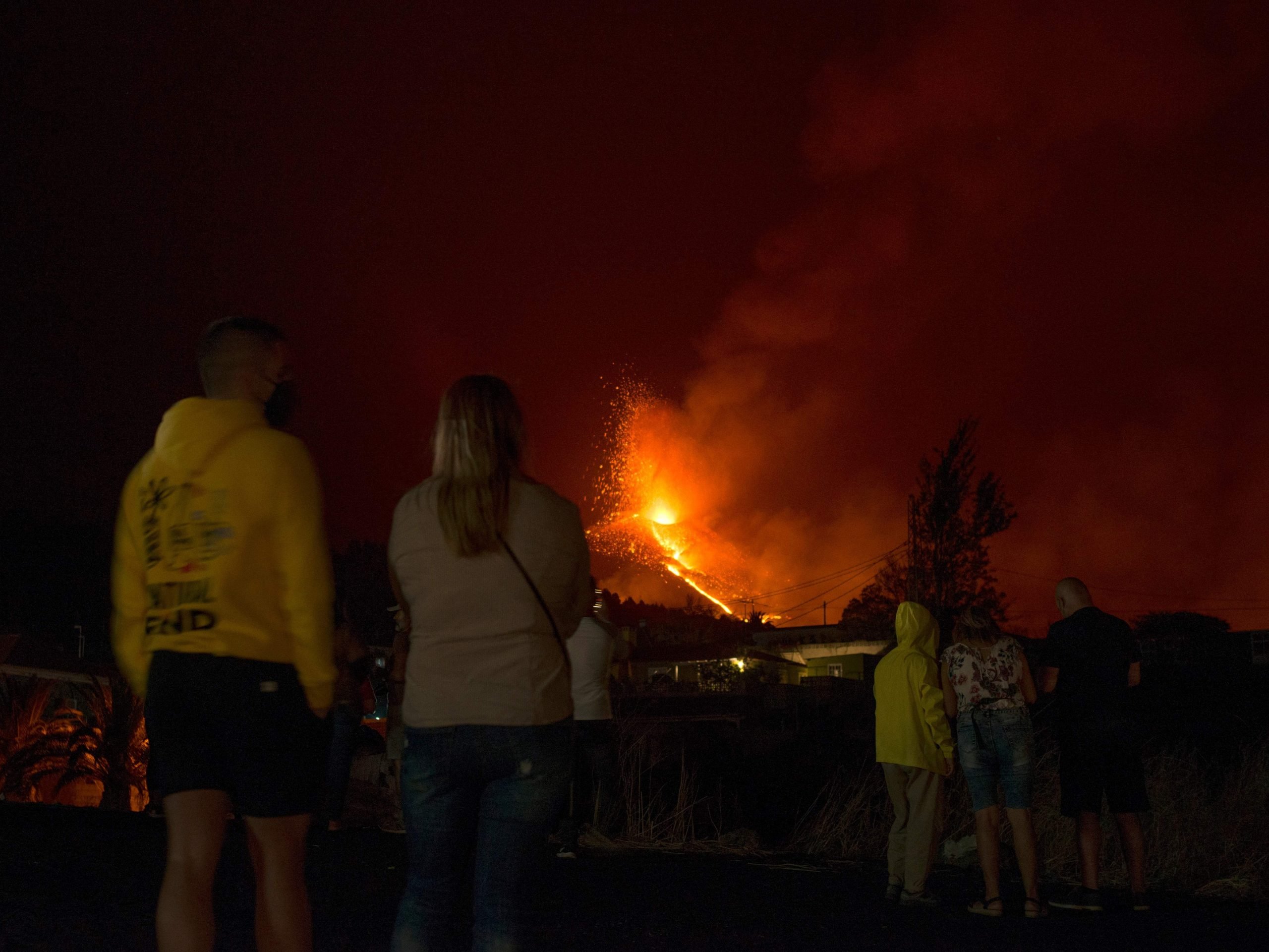 People observe the Cumbre Vieja volcano spewing lava, ash and smoke from El Paso, in the Canary Island of La Palma late on October 2, 2021