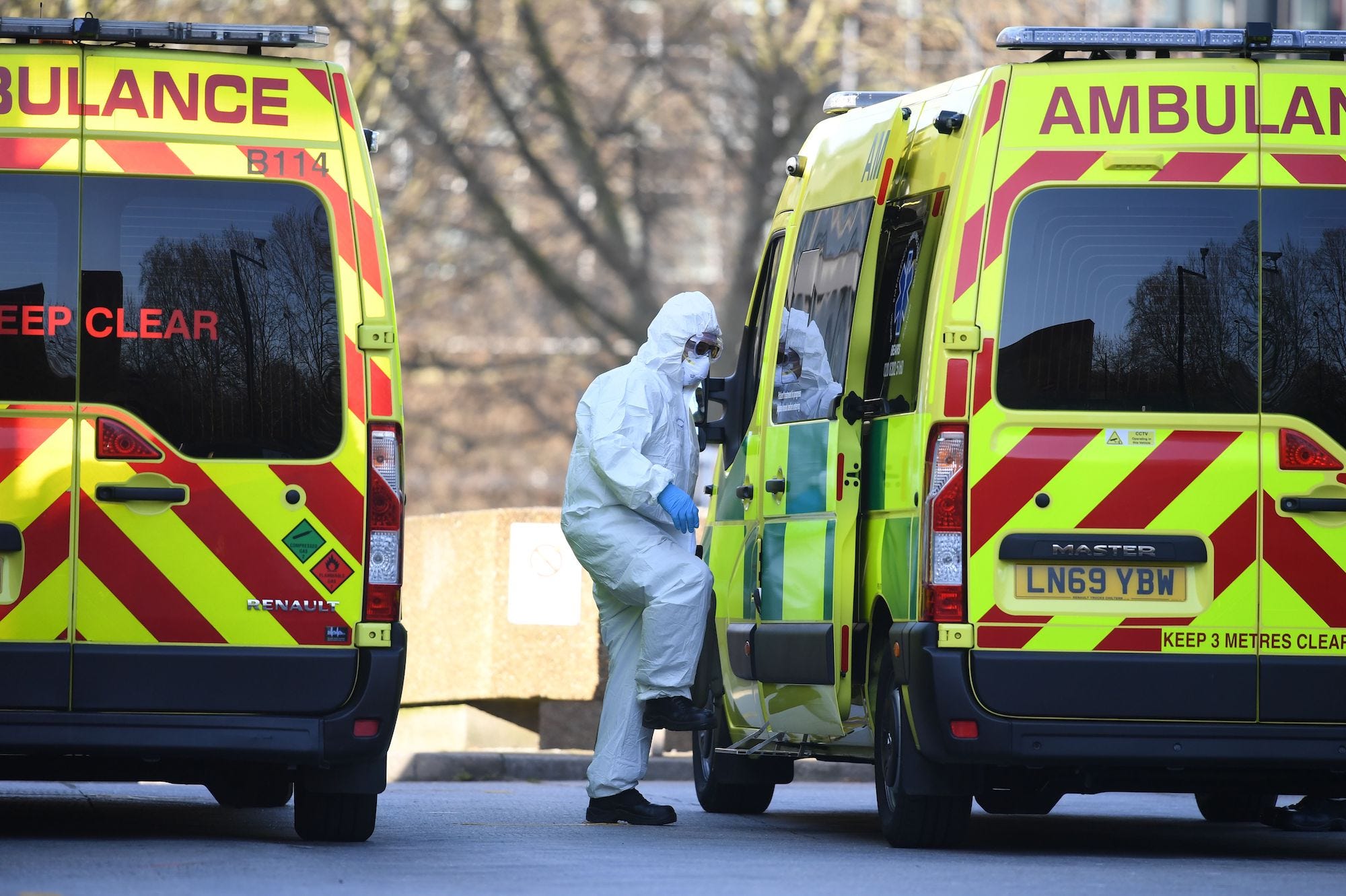 A member of the ambulance service wearing personal protective equipment is seen leading a patient (unseen) into an ambulance at St Thomas' Hospital in London on March 24, 2020. - Britain's leaders on Tuesday urged people to respect an unprecedented countrywide lockdown, saying that following advice to stay at home would stop people dying of coronavirus