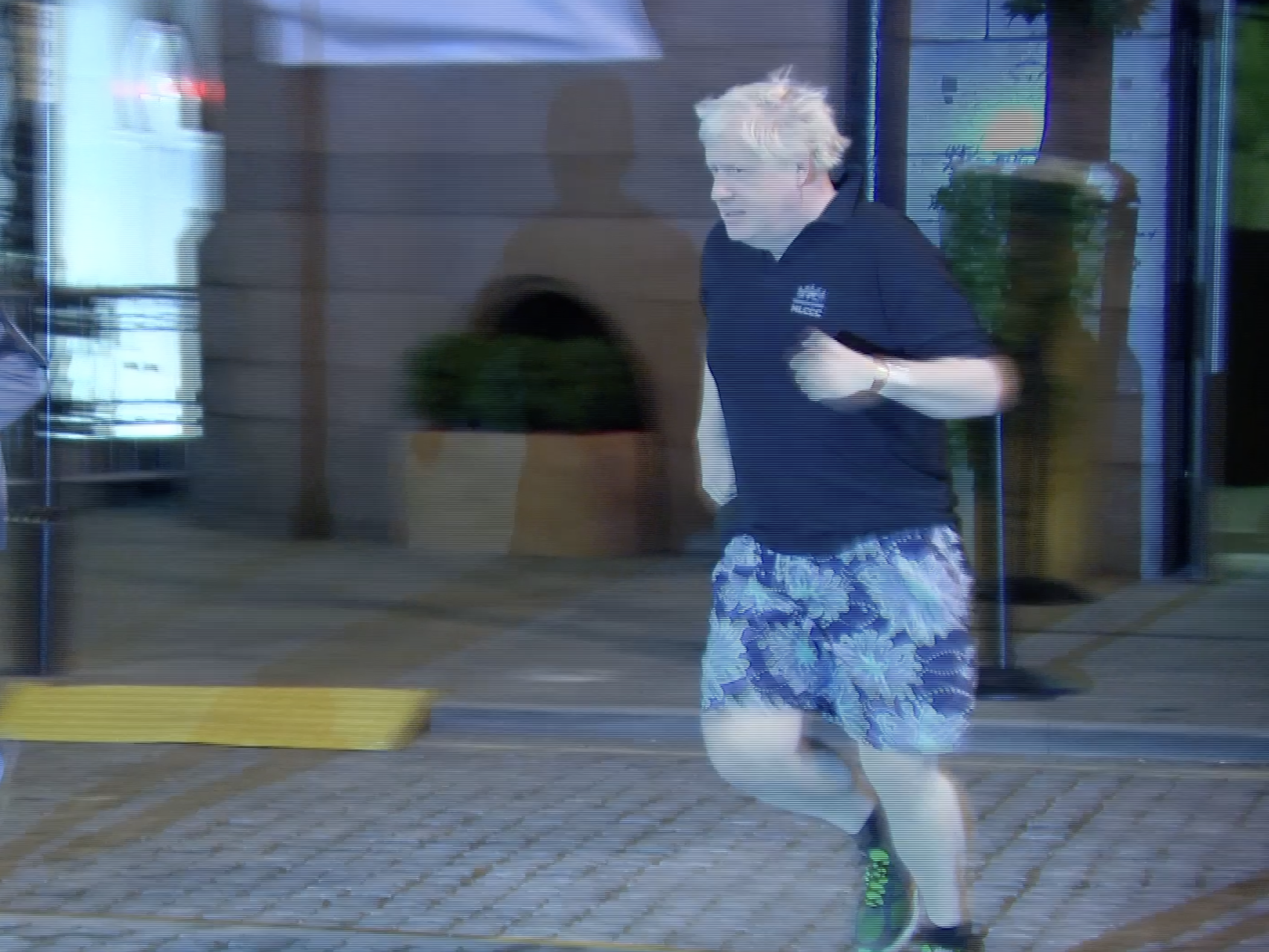 Boris Johnson jogging in black Bermuda shorts.