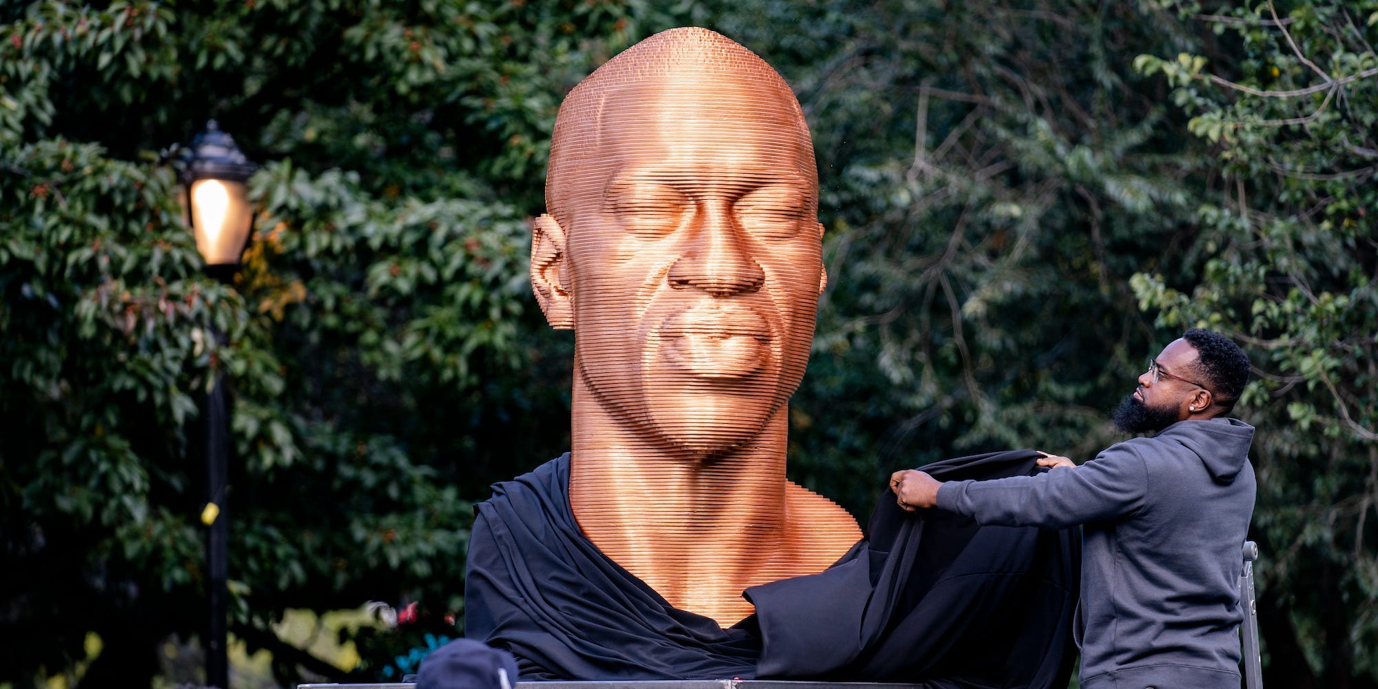 In this Thursday, Sept. 30, 2021, file photo, a sculpture of George Floyd, one of three sculptures as part of the "SEEINJUSTICE" art exhibition that also feature the likenesses of Breonna Taylor and John Lewis, is unveiled as Floyd's brother Terrence, second from left, looks at Union Square in the Manhattan borough of New York.