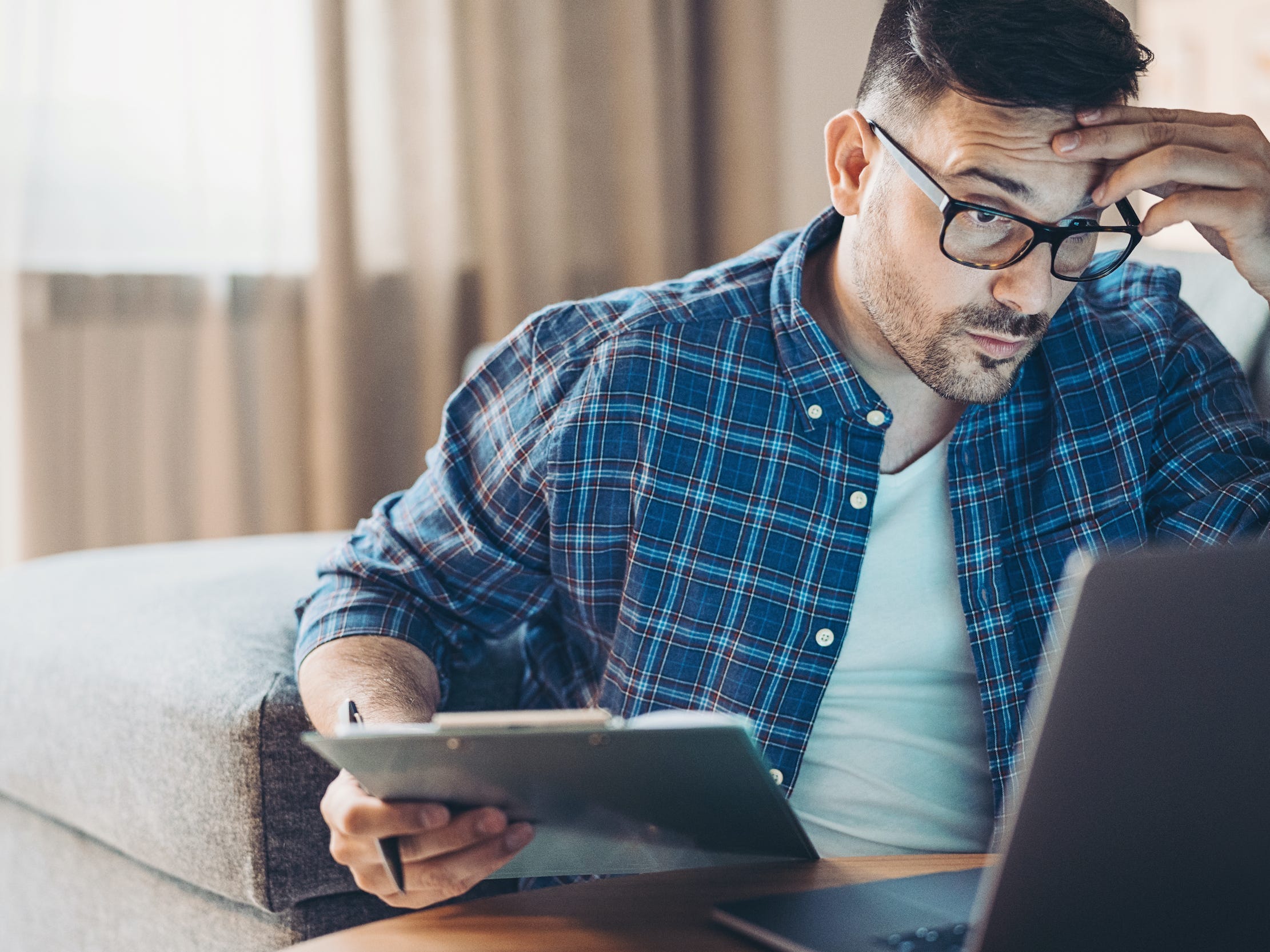 frustrated man working on laptop computer at home