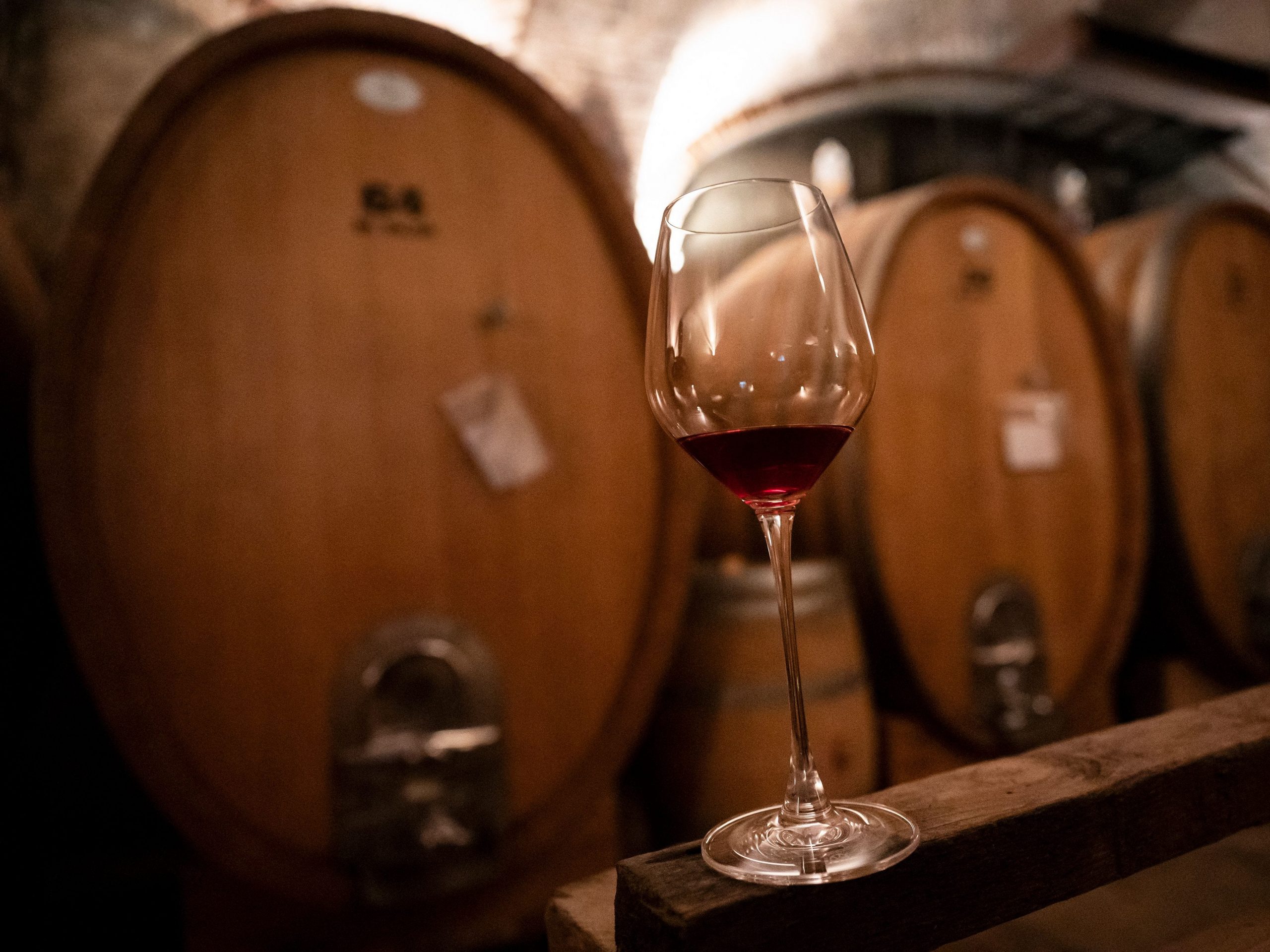 A glass of red wine is pictured in the cellar of Matteo Correggia Winery on September 2, 2021 in Canale d'Alba, Roero countryside, Northwestern Italy.