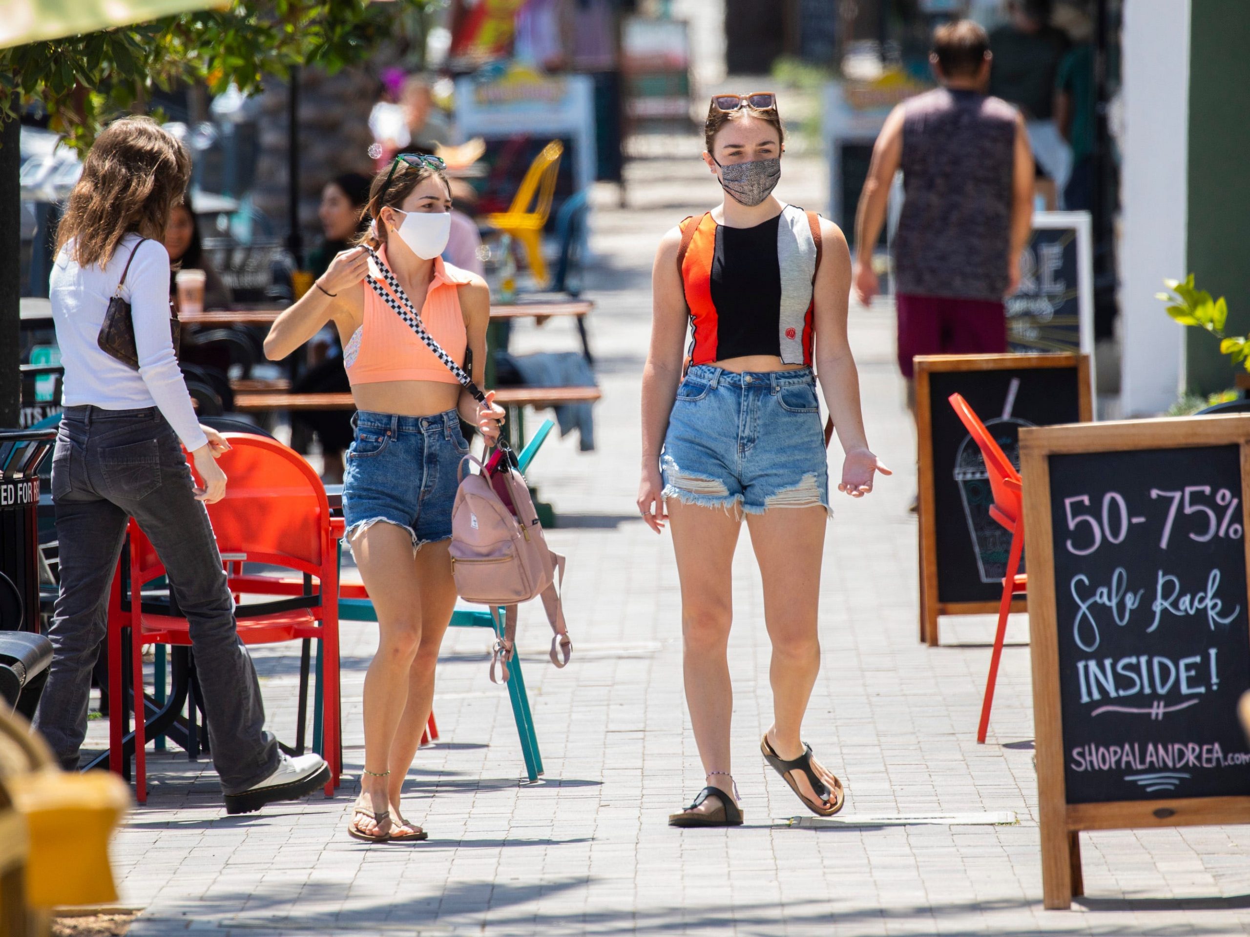 Two masked women walk along S. Catalina Avenue in the Riviera Village shopping area of Redondo Beach, CA.