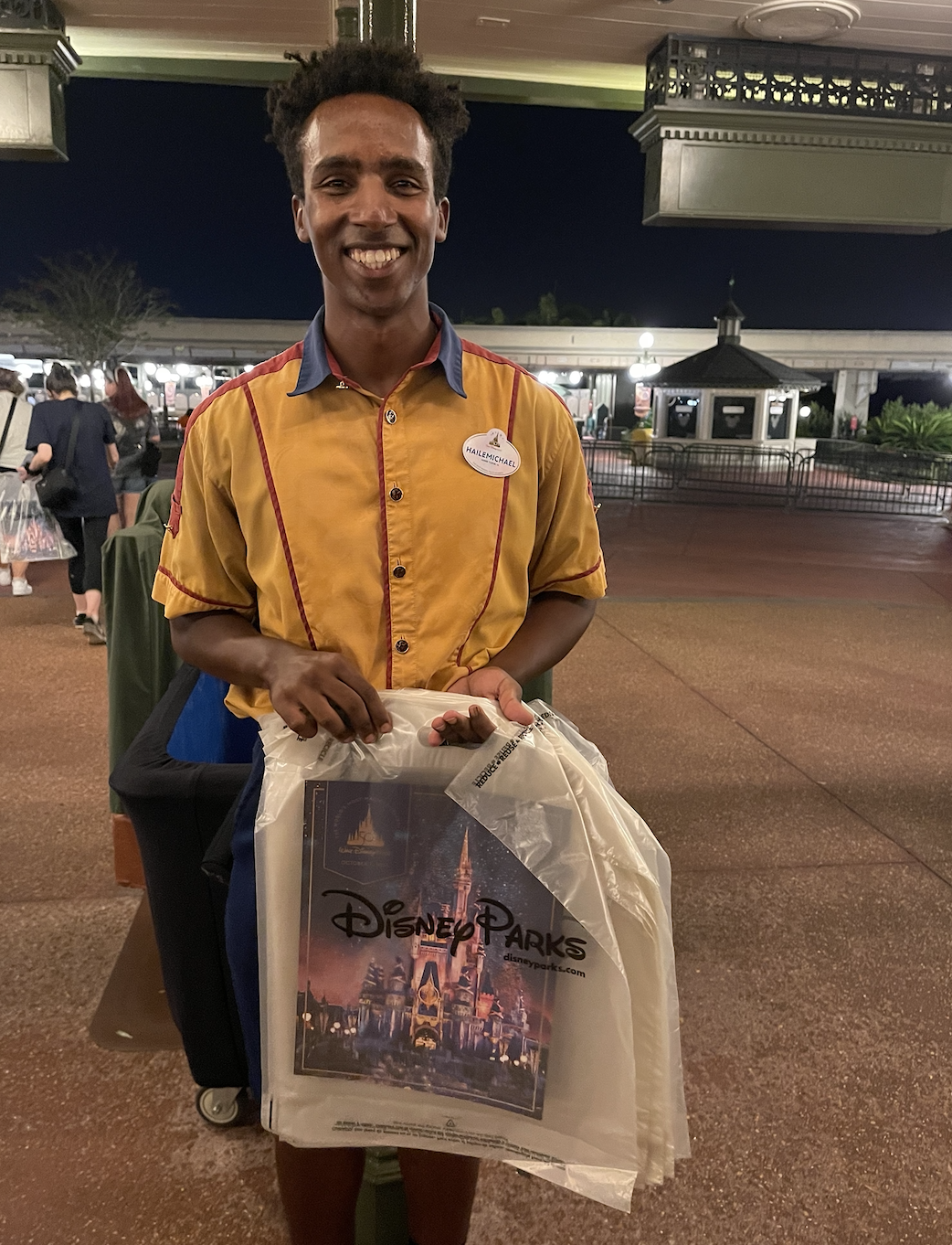 cast member handing out commemorative posters on opening day of 50th anniversary celebration disney world