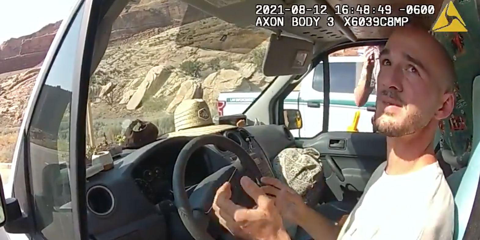 A Utah police officer's bodycam view of Brian Laundrie in the drivers' seat of a van. Laundrie is gesturing while talking.