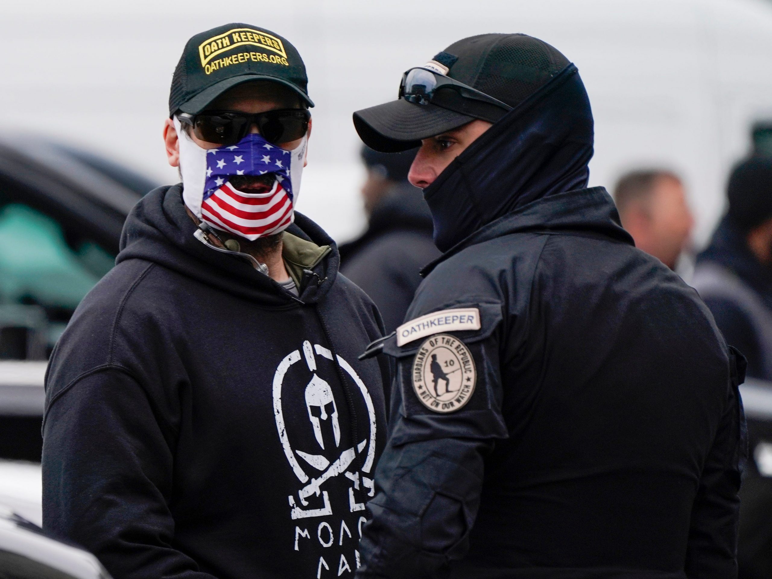 People wearing hats and patches indicating they are part of Oath Keepers attend a rally at Freedom Plaza Tuesday, Jan. 5, 2021, in Washington, in support of President Donald Trump.