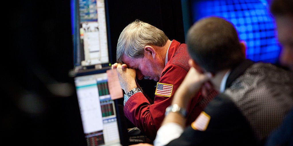 A trader rested his head on his hands while working during afternoon trading on the floor of the New York Stock Exchange