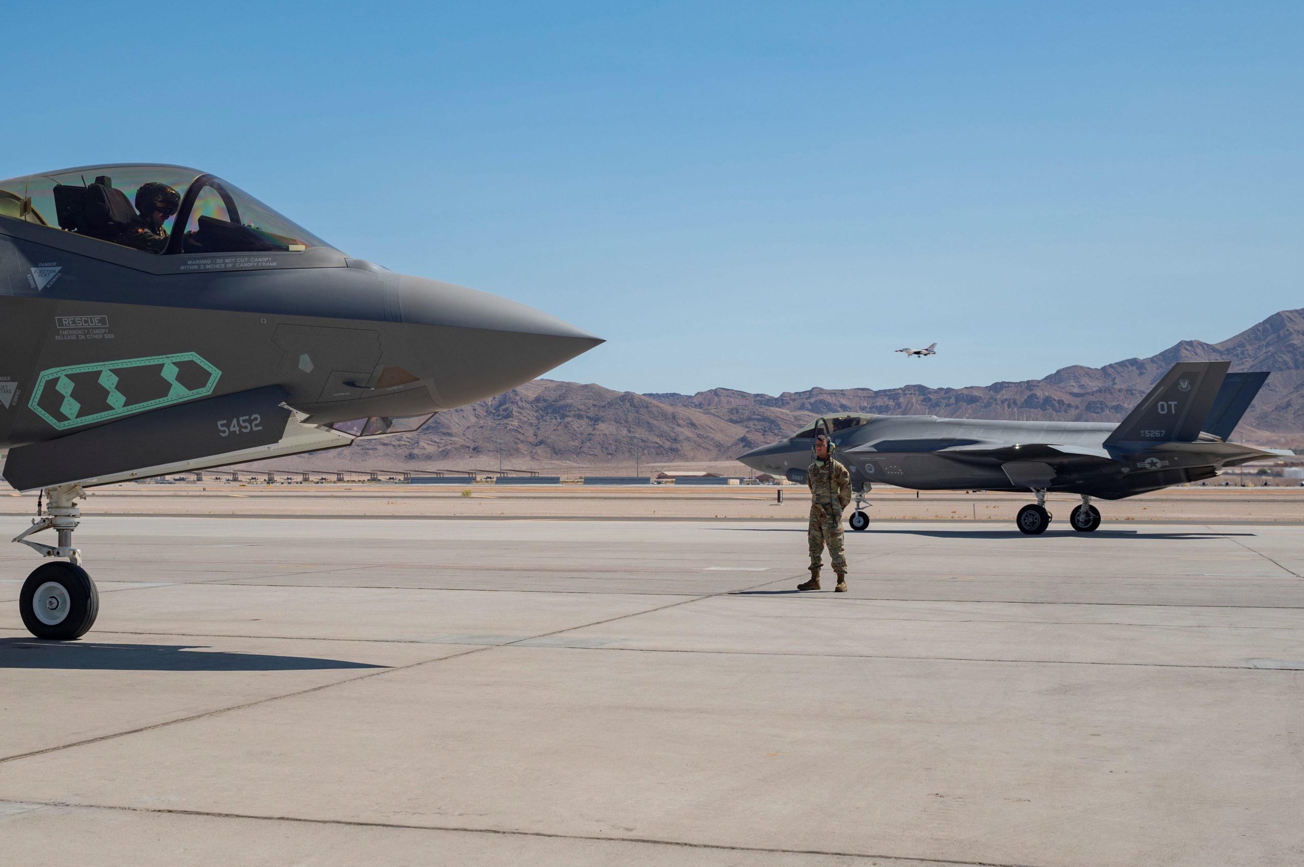Airman 1st Class Javier Farcia-Bustos waits for an F-35A pilot assigned to the 442nd Test and Evaluation Squadron to complete pre-flight checks on the flight line at Nellis Air Force Base, Nevada, Sept. 21, 2021