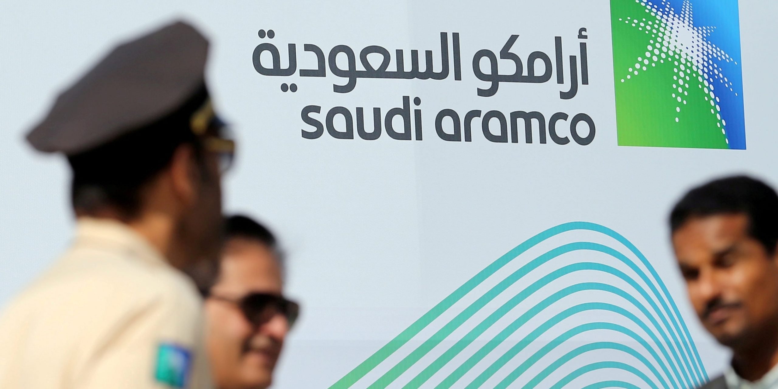 FILE PHOTO: The logo of Aramco is seen as security personnel stand before the start of a press conference by Aramco at the Plaza Conference Center in Dhahran, Saudi Arabia November 3, 2019. REUTERS/Hamad I Mohammed/File Photo