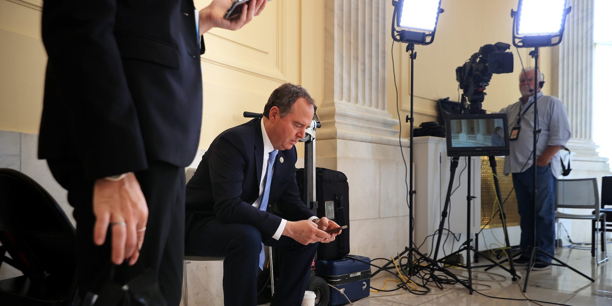 Democratic Rep. Adam Schiff of California checks his phone in between television interviews in the Cannon House Office Building on July 26, 2021.