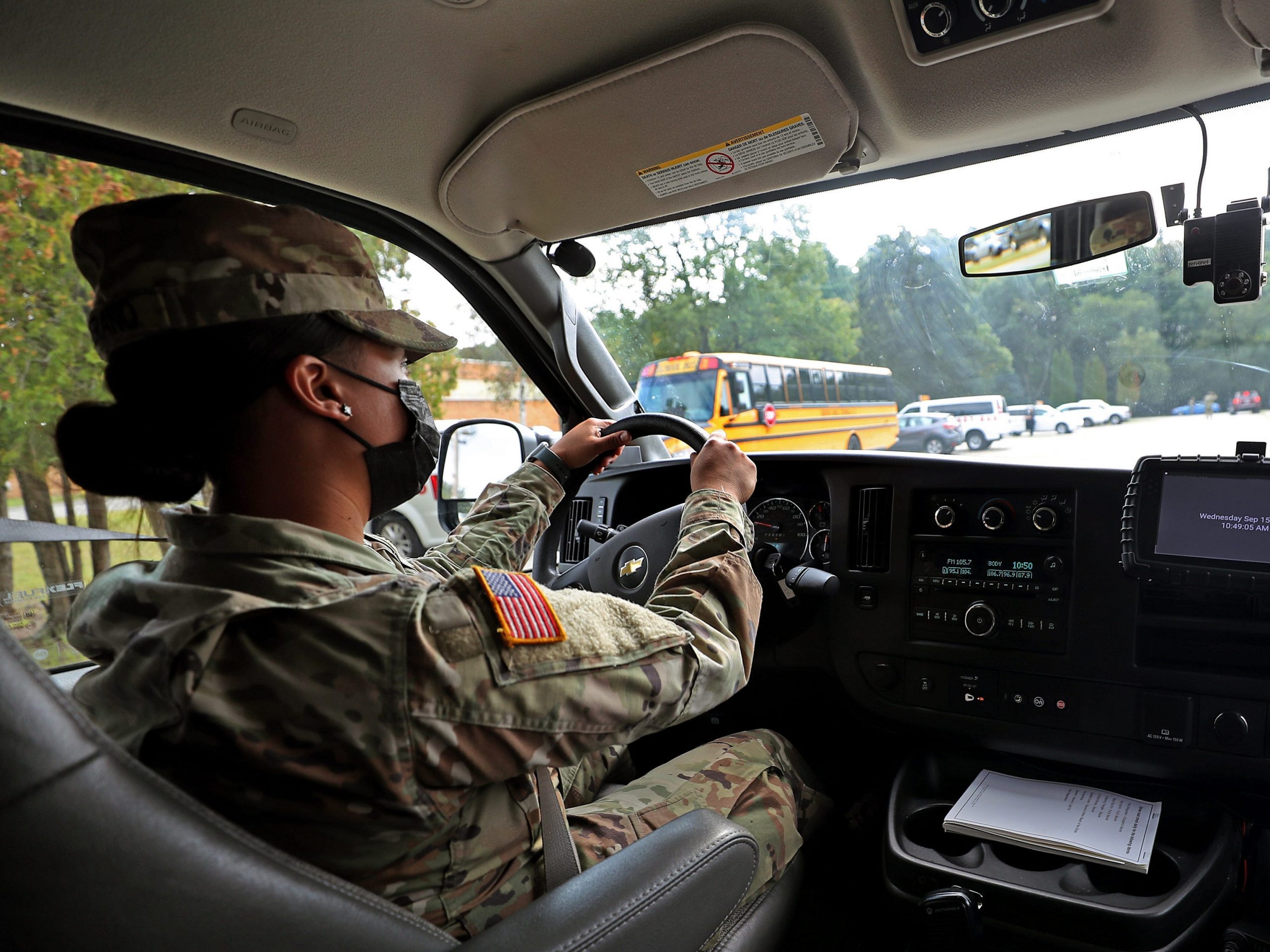 A member of the National Guard drives a school bus.