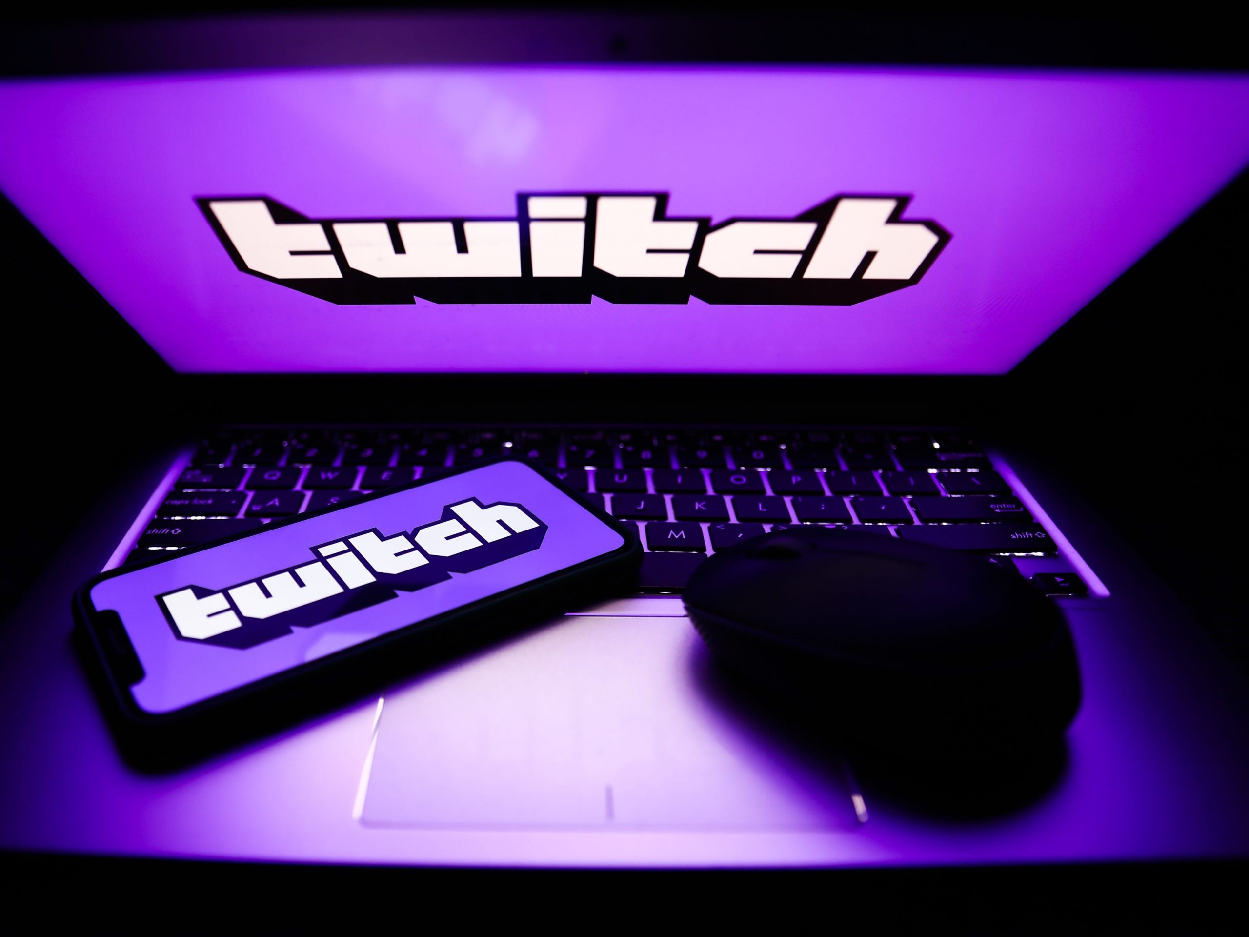 Twitch logos are seen displayed on a phone and a laptop screens in this illustration photo.