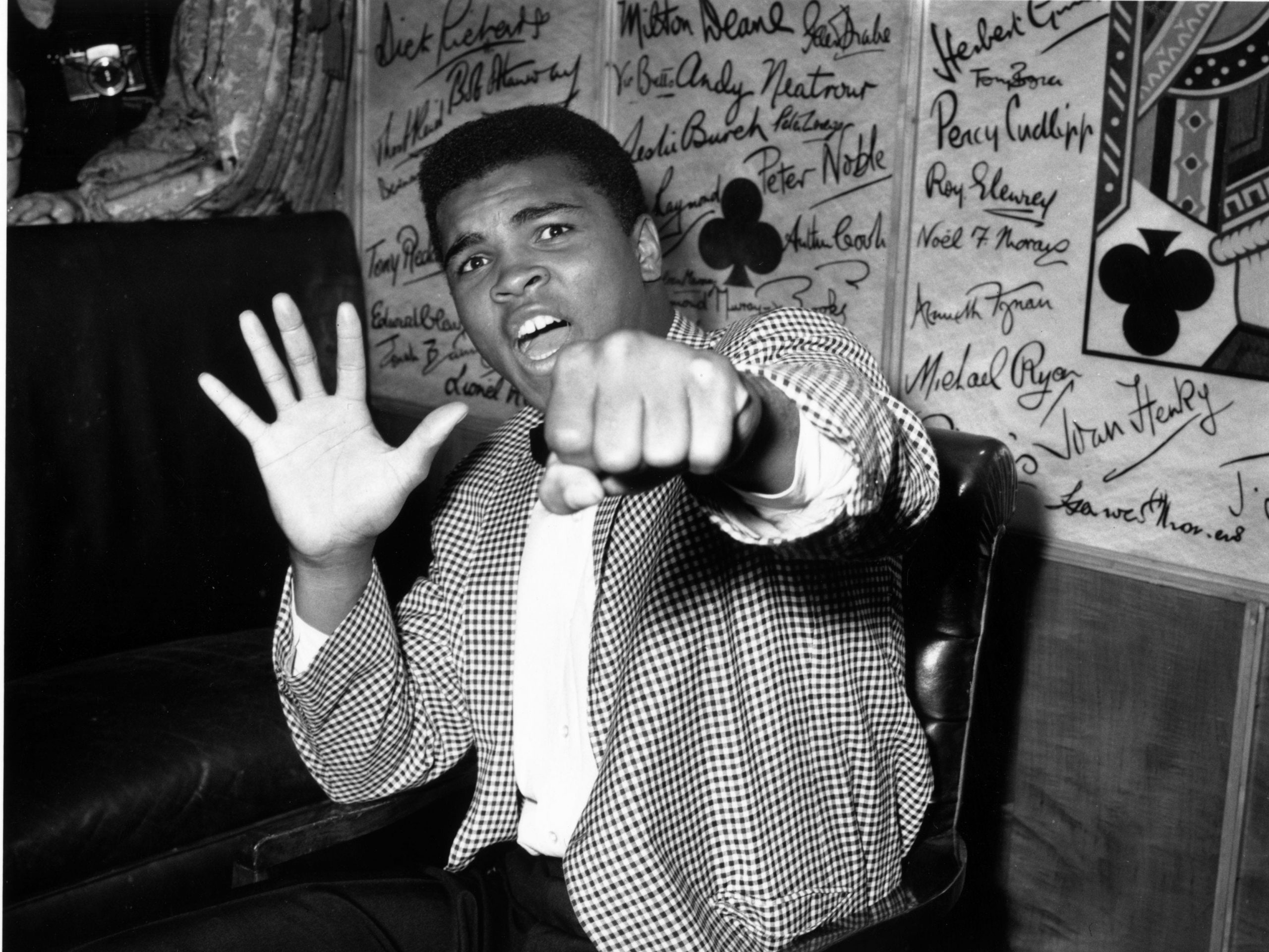 Supremely confident American boxer Cassius Clay holds up five fingers in a prediction of how many rounds it will take him to knock out British boxer Henry Cooper.