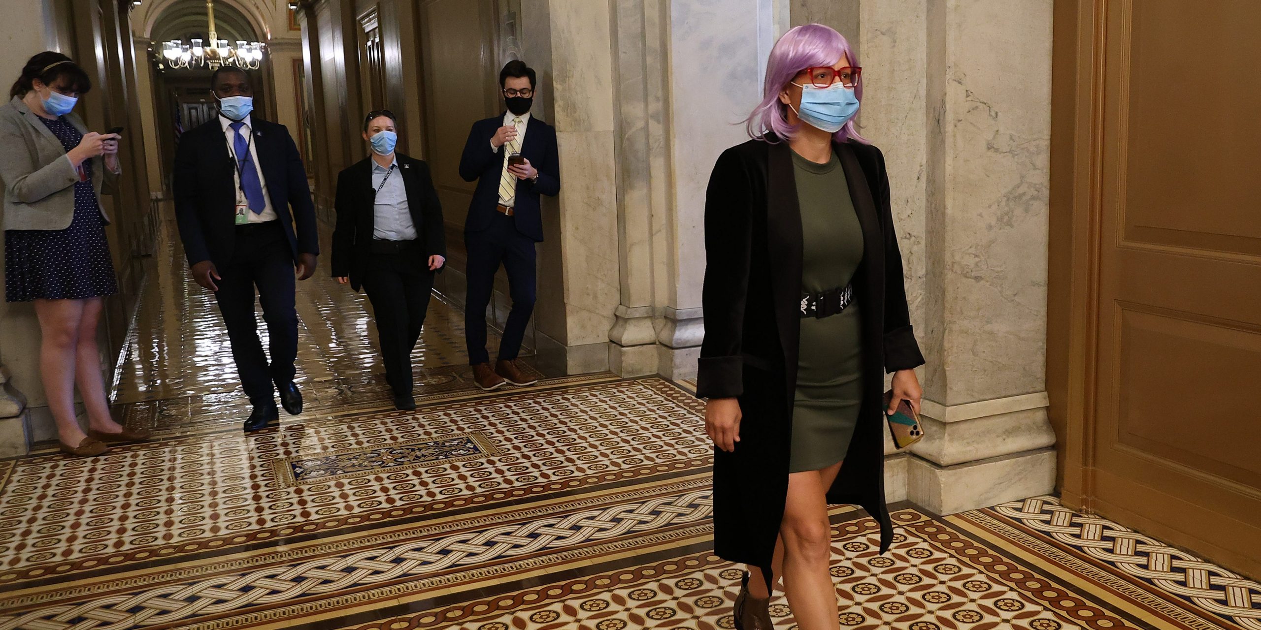 Senator Kyrsten Sinema walks down a hall of the US Capitol.