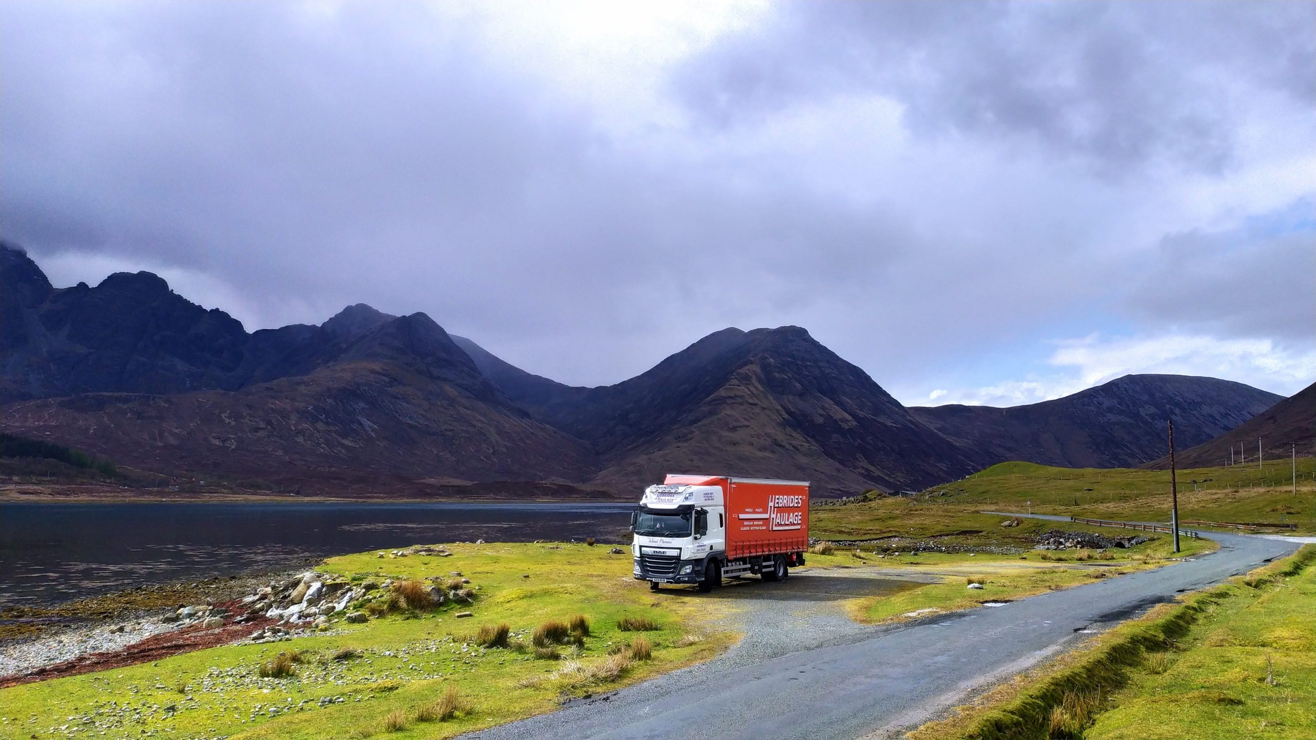 Truck parked in the Scottish Highlands with mountains in background.