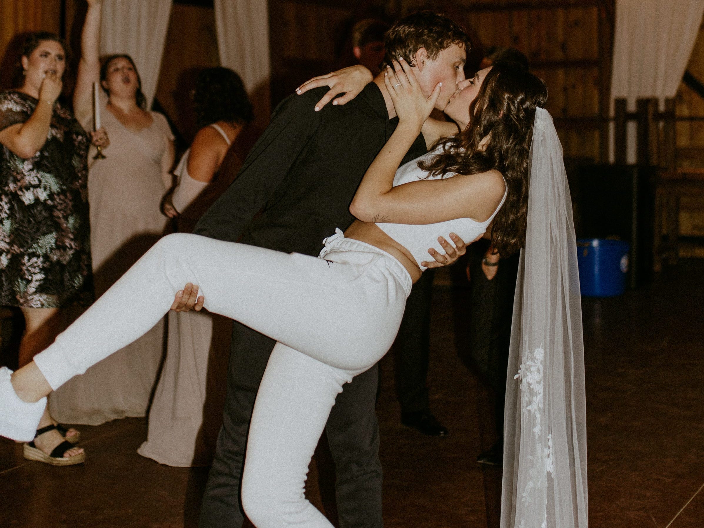 Alayna and Gunner Tripp are photographed wearing coordinating Nike sweat suits at their wedding reception.