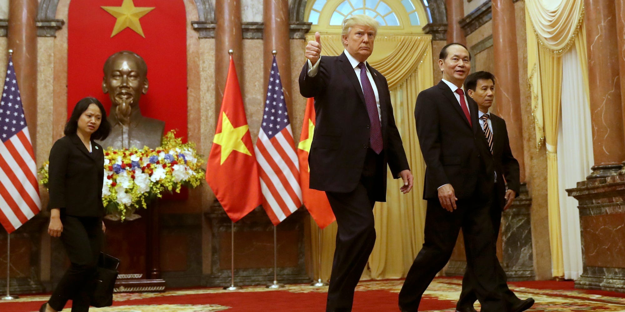 President Donald Trump, center, and Vietnamese President Tran Dai Quang, center right, arrive for the bilateral meeting at the Presidential Palace, Sunday, Nov. 12, 2017, in Hanoi, Vietnam.