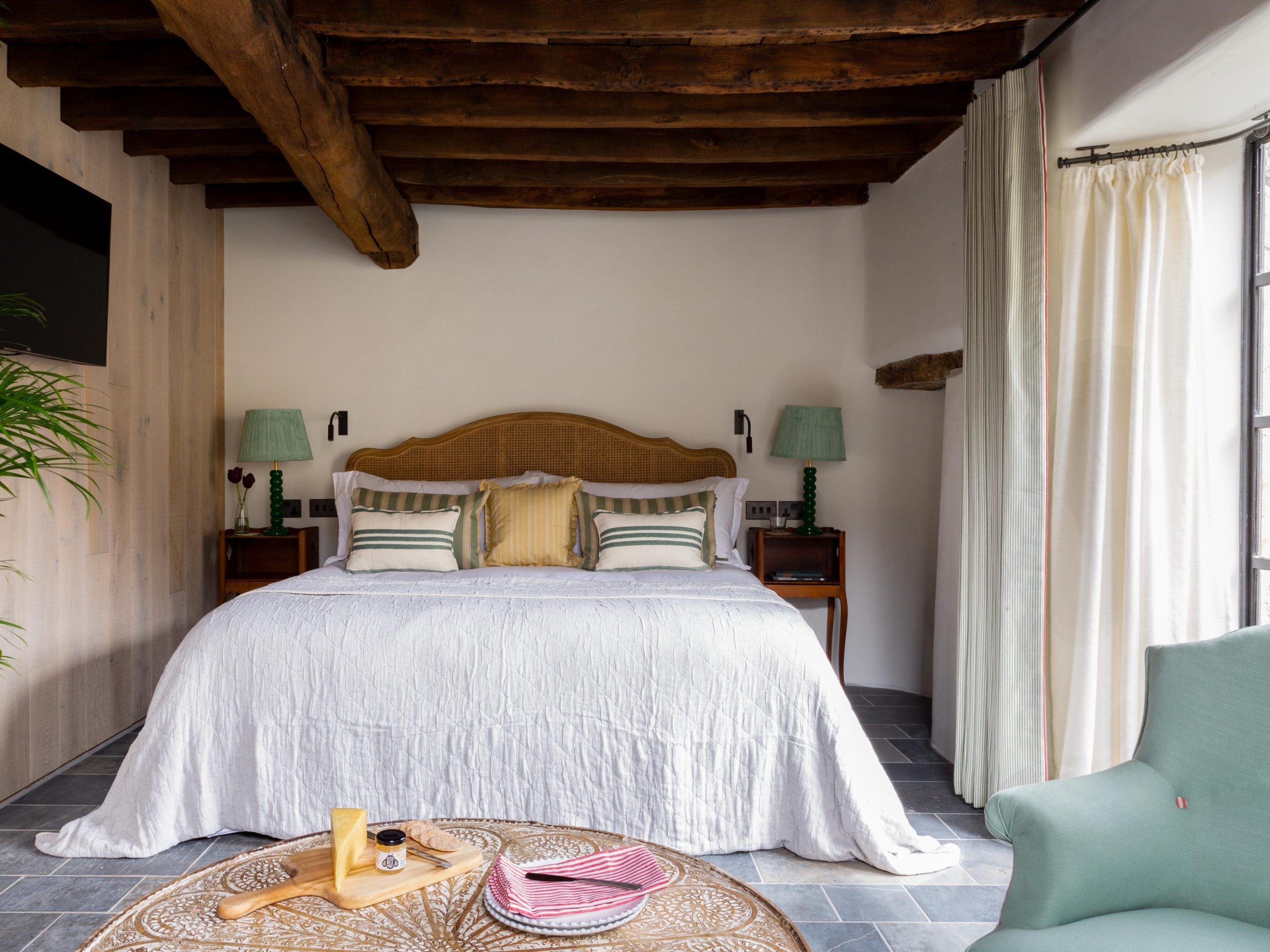 A bedroom with exposed wood beams.